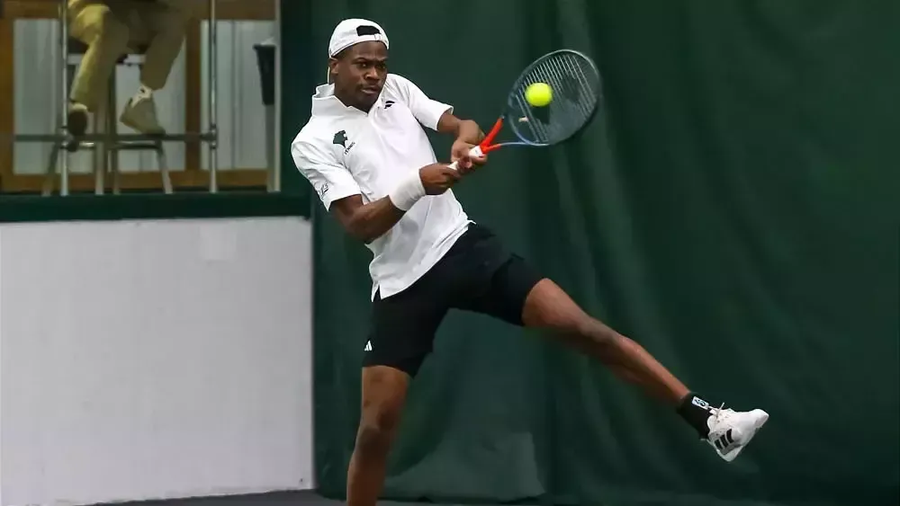 Tennis Student Athlete Andrew Kunaka hitting a tennis ball 