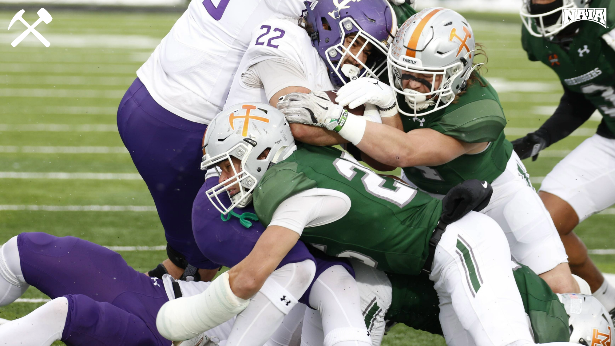 Montana Tech football players tackle an opponent during a home game
