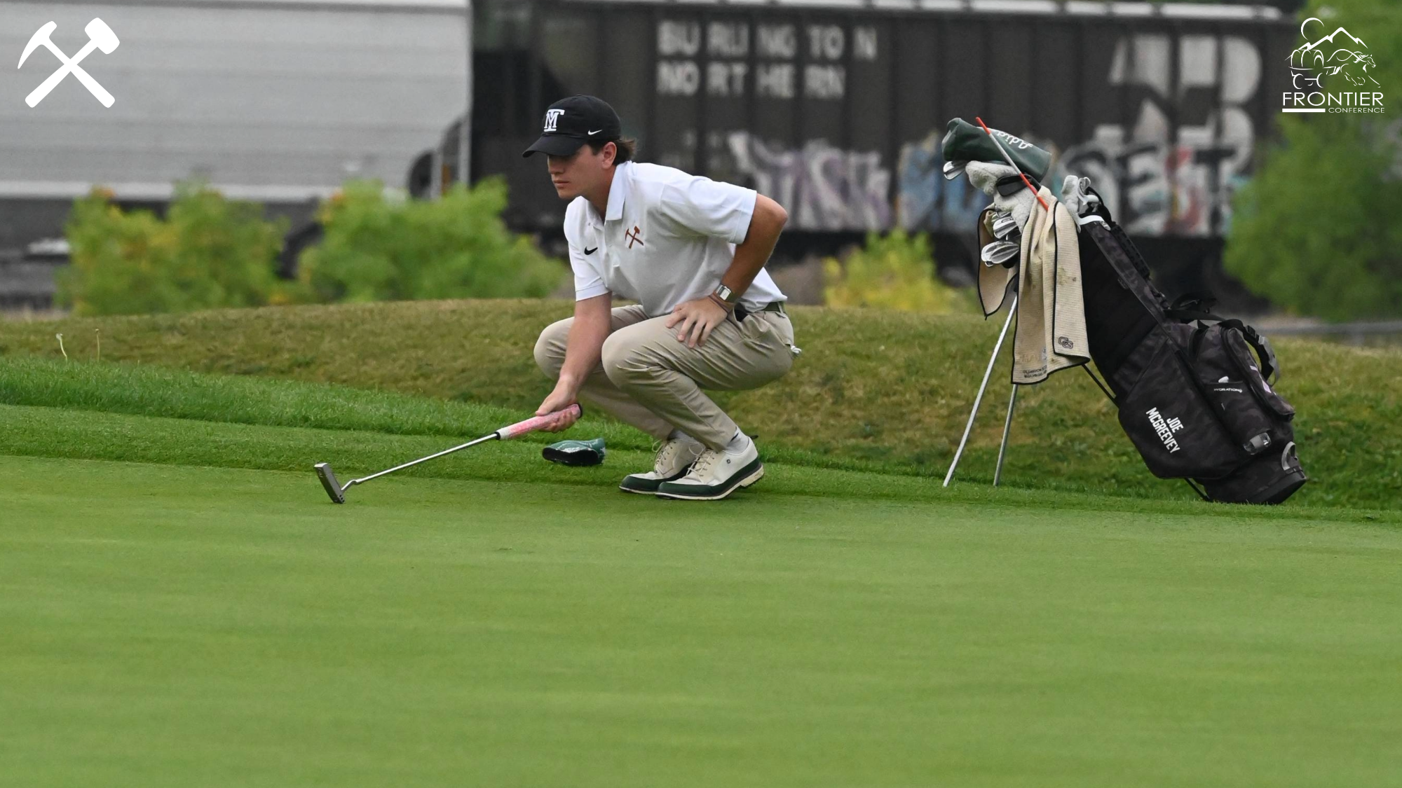 Joe McGreevey squats judging a putt during a college golf tournament