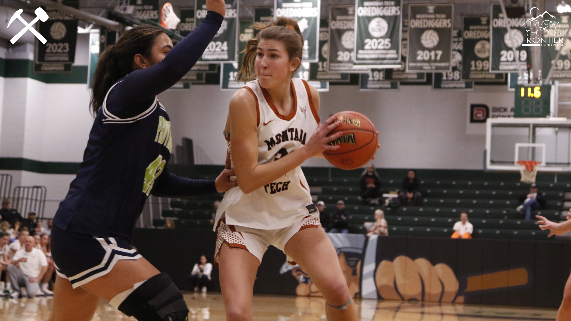 Halle Haber handling the basketball against a defender during a Montana Tech women's basketball game