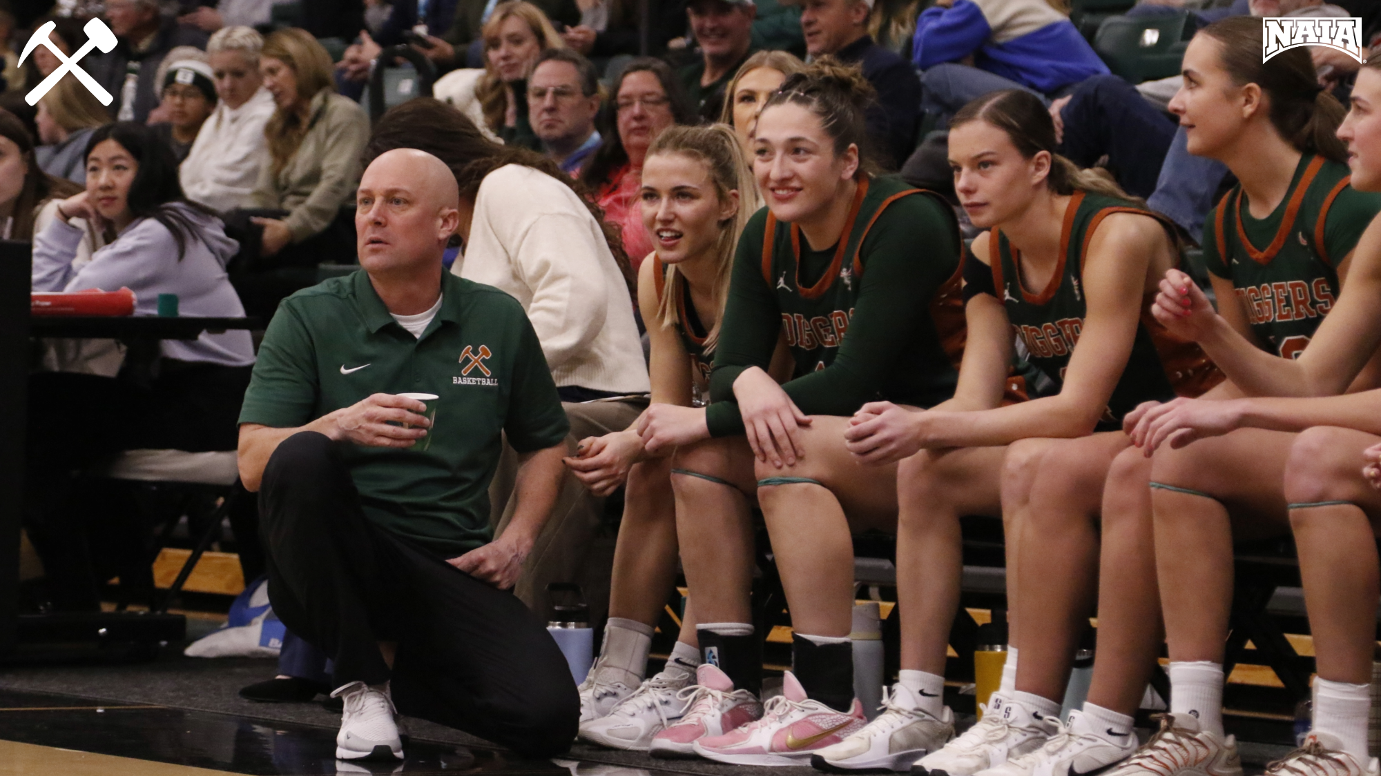 Montana Tech women's basketball players watch the game from the bench