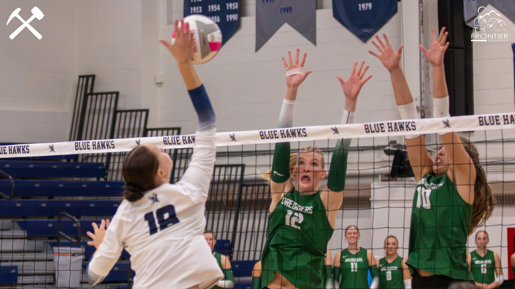 Montana Tech volleyball players jump to block an attack attempt