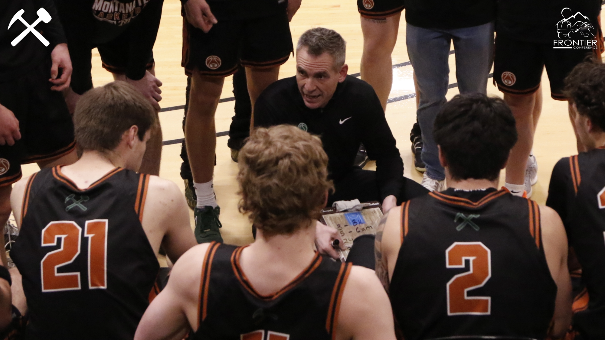 Men's basketball team huddles in a timeout