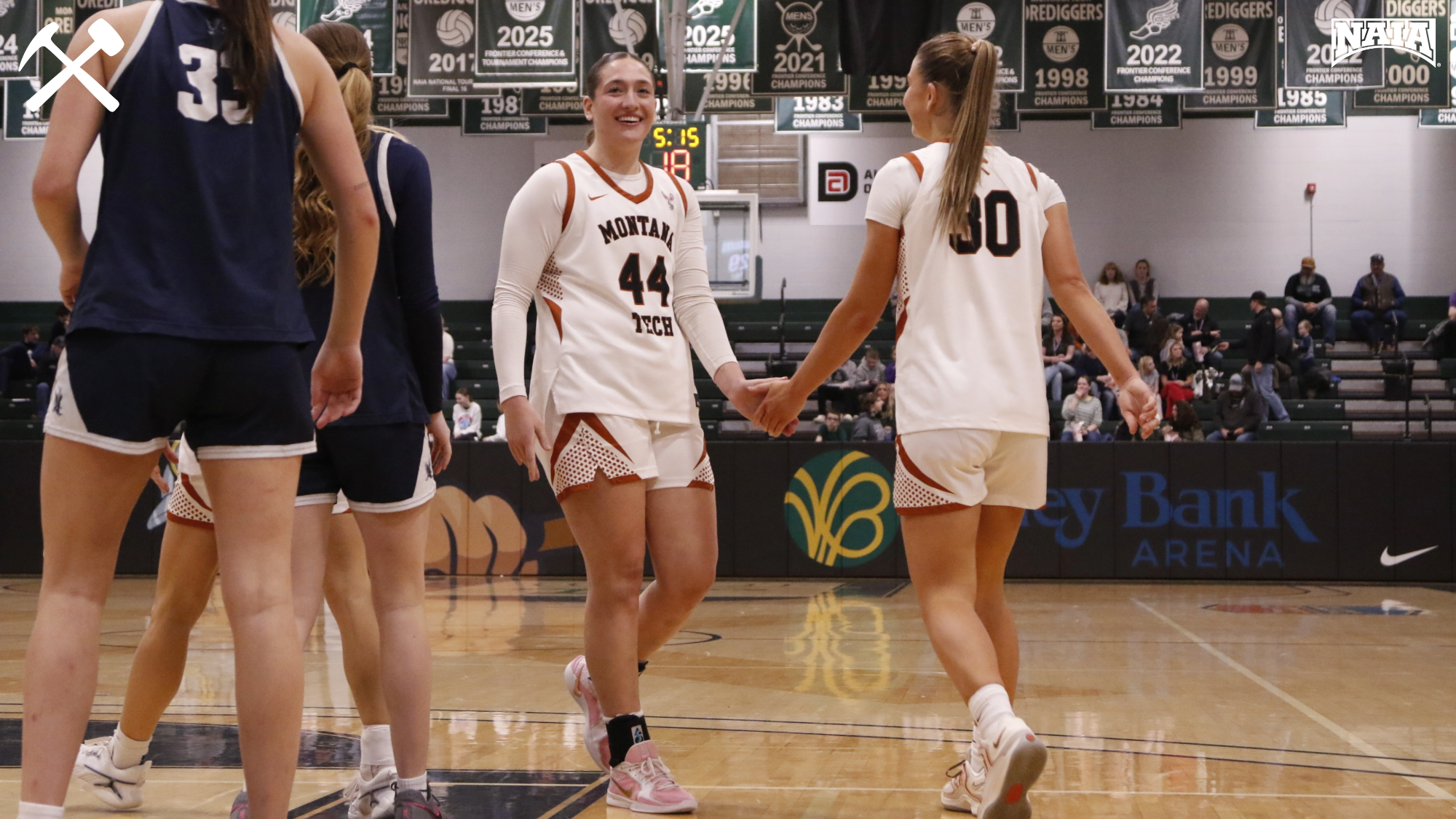 Montana Tech women's basketball players high five during a home game