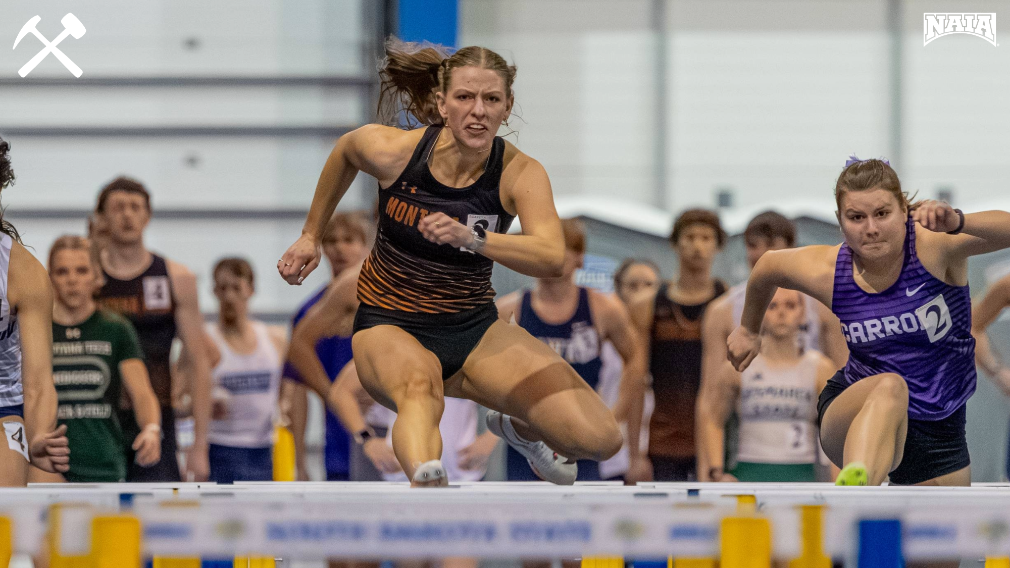 Abby Clark jumping a hurdle during an indoor track race