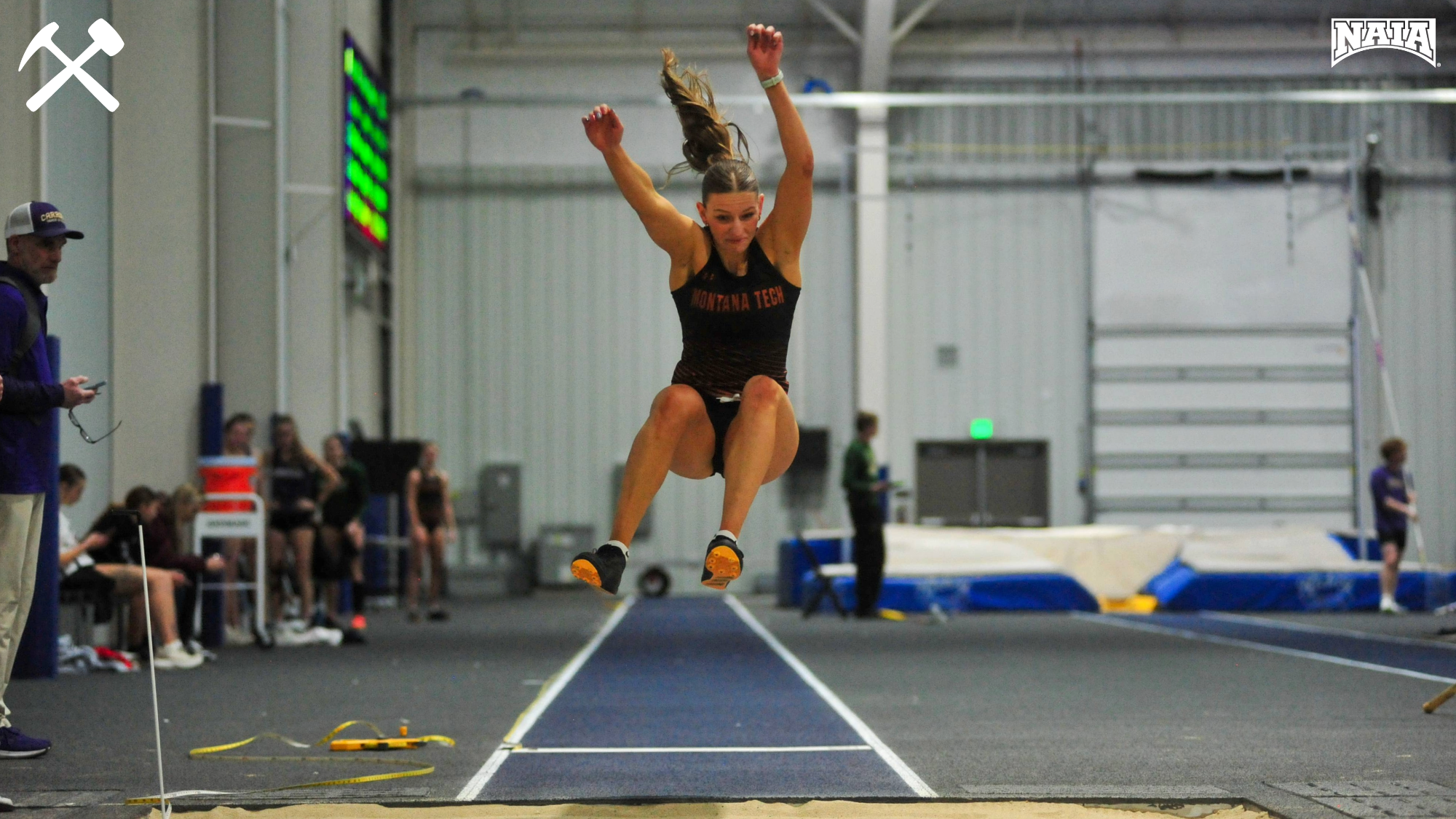 Abby Clark long jumping in an indoor track & field meet