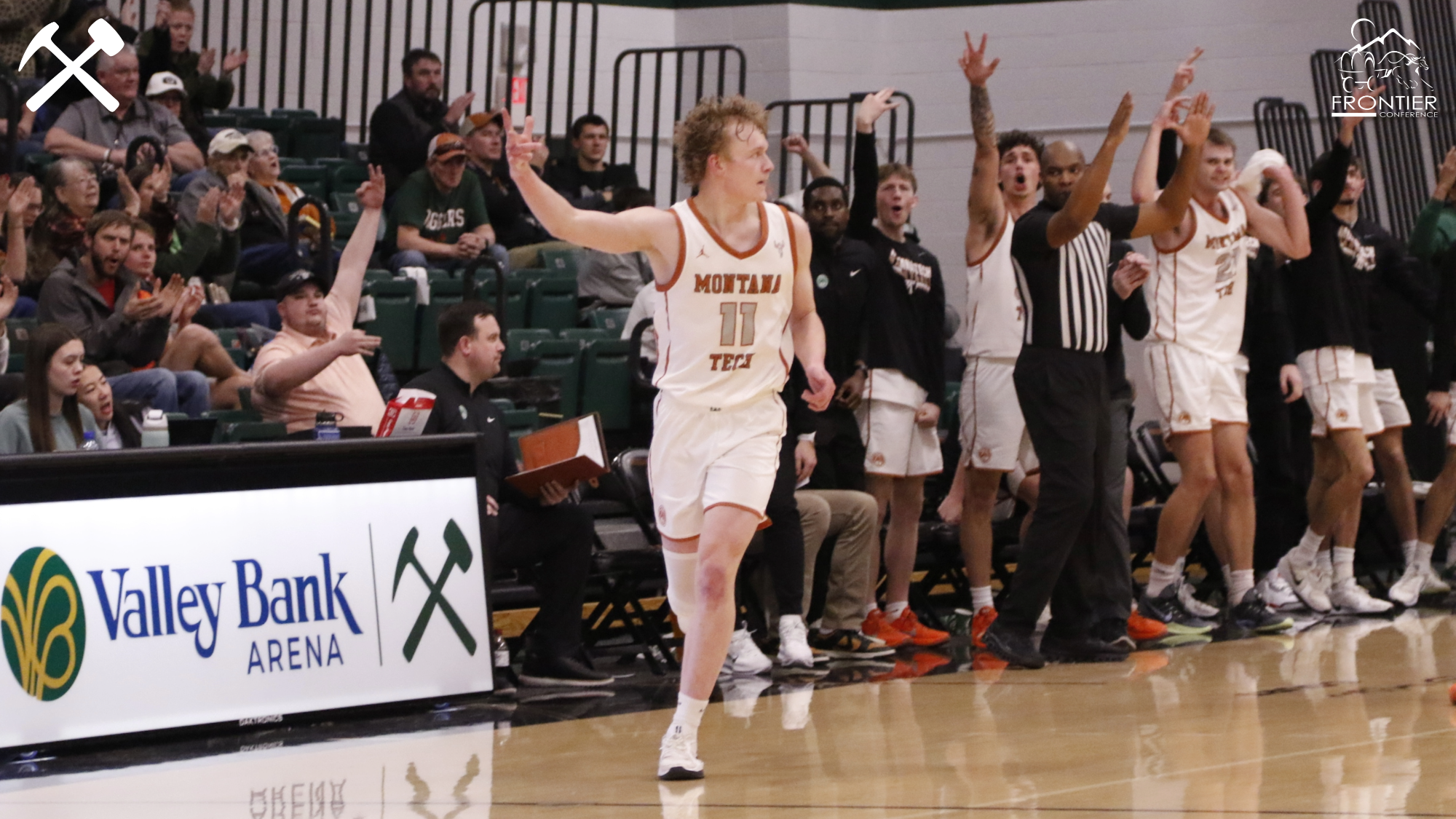 Hayden Diekhans celebrates a made 3-pointer with teammates in the background during a Montana Tech home basketball game
