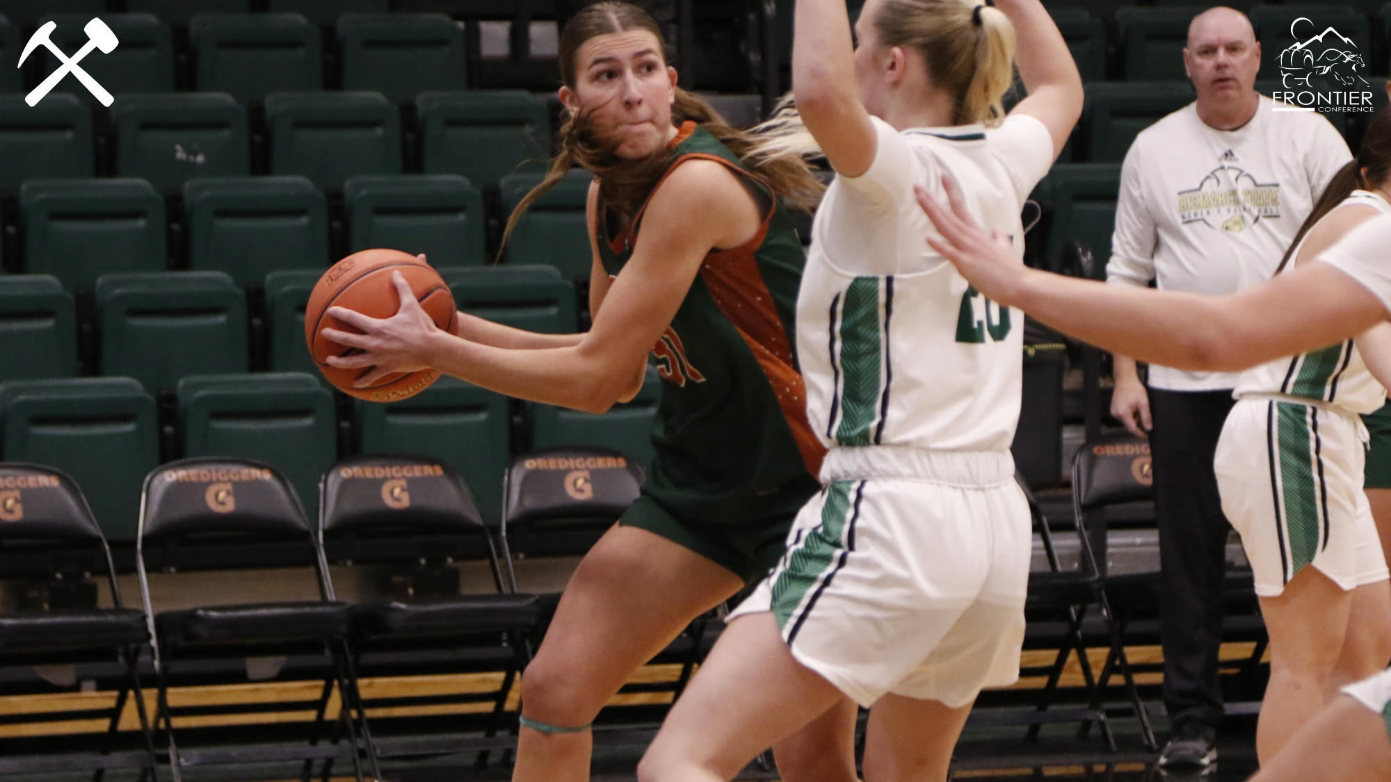 Montana Tech's Halle Haber looks to pass the ball around a defender in a women's basketball game