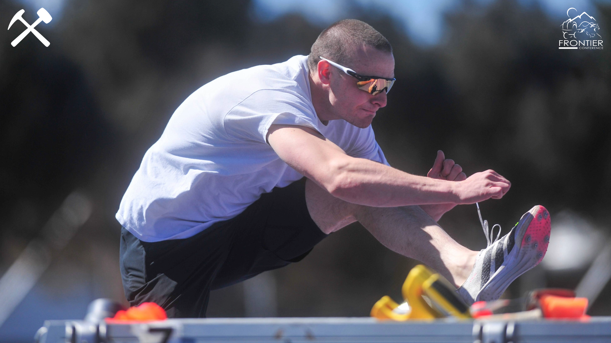 Adam Schrader warms up for a hurdles race by jumping hurdles