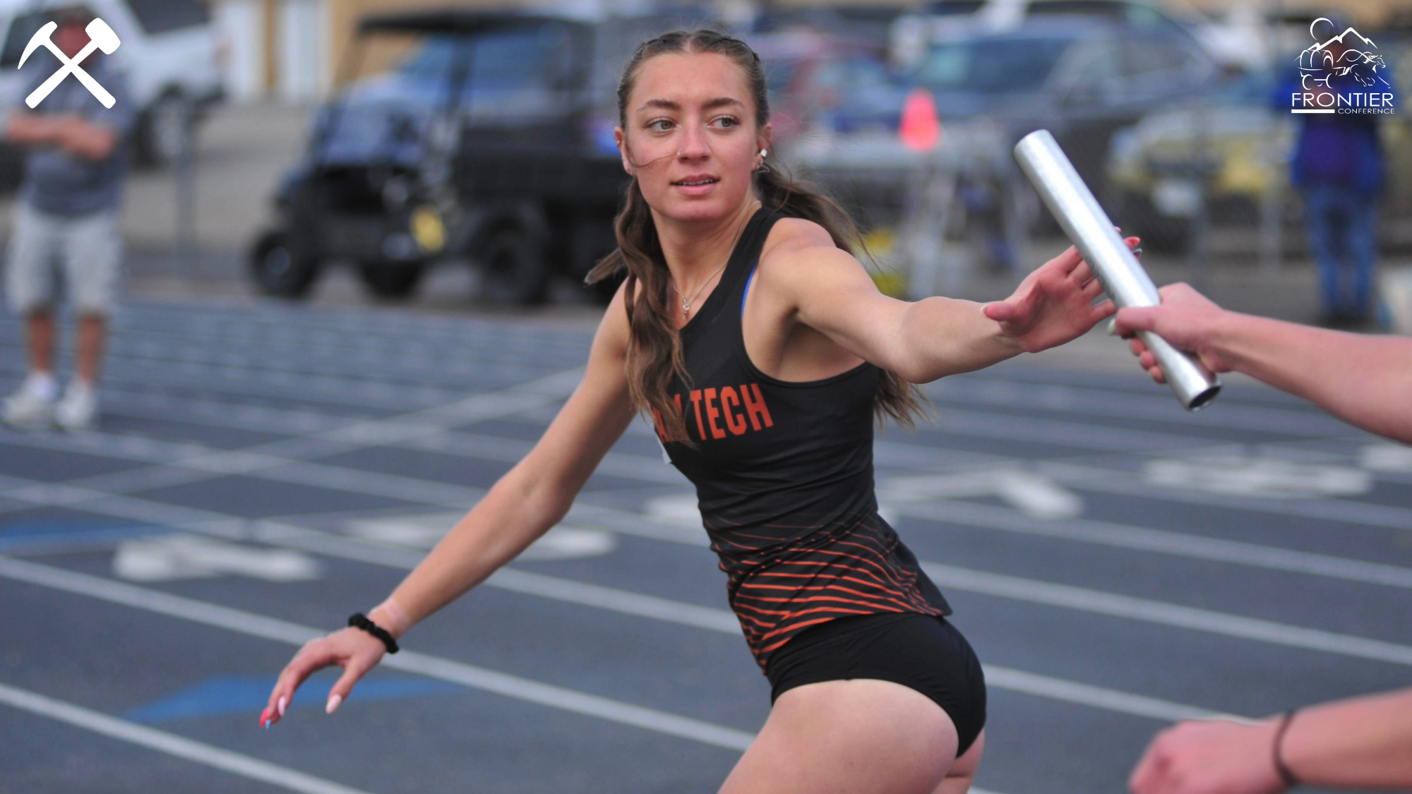 Kamryn Comba takes a relay baton during a race