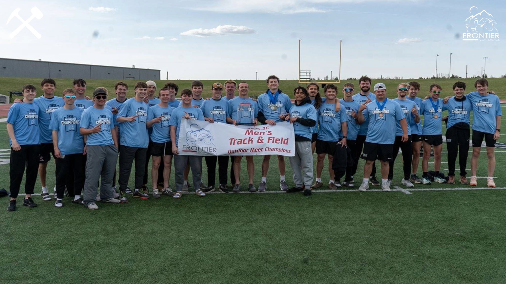 Montana Tech's men's track & field team poses with the championship trophy and banner