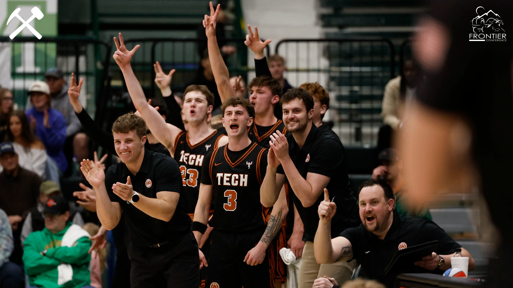 Montana Tech men's basketball players celebrate a basket from the bench