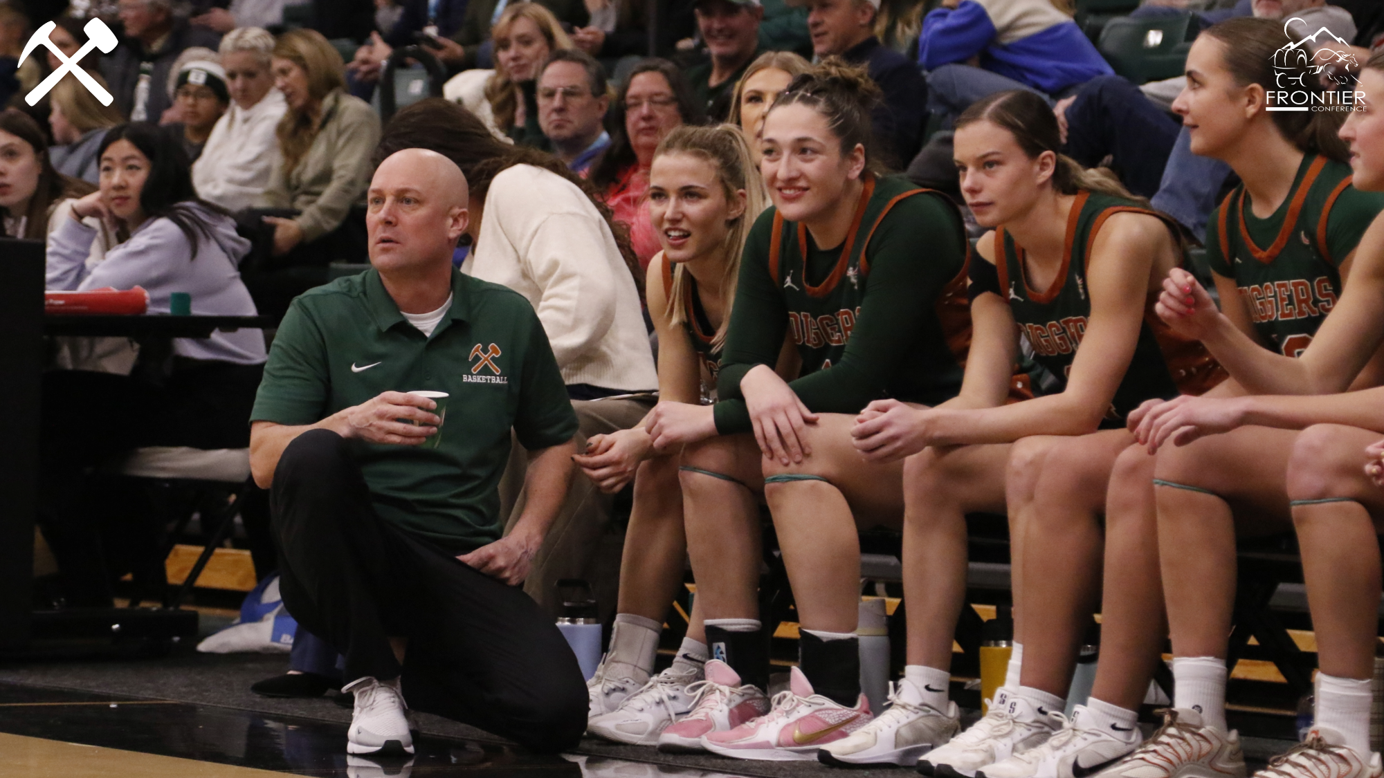 Coach Jeff Graham and players on the bench during a women's basketball game