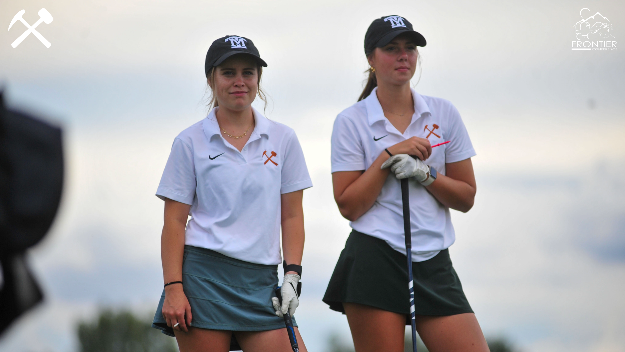 Montana Tech women's golfers Olivia McGreevey and Keni Wade stand on the tee box with clubs during a practice round