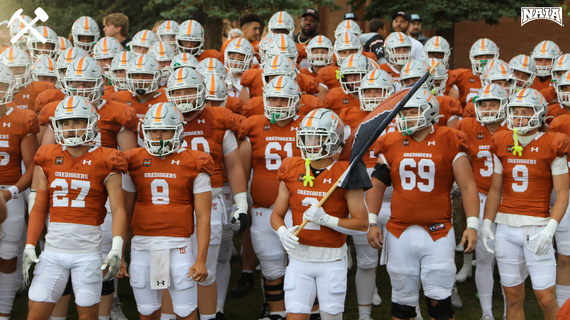 Montana Tech's football team prepares to take the field in copper uniforms.
