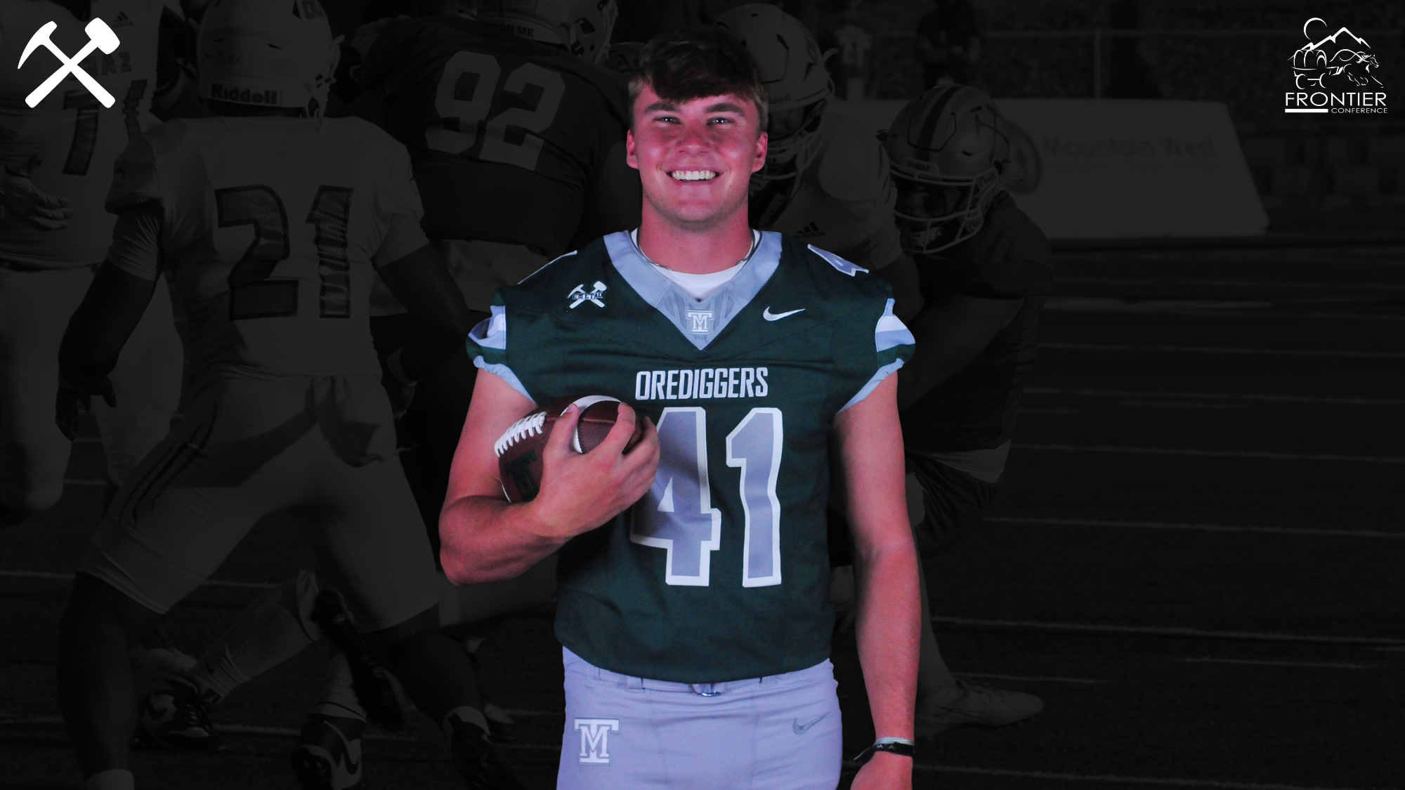 Asher Feddes smiles and holds a football wearing a green Montana Tech uniform