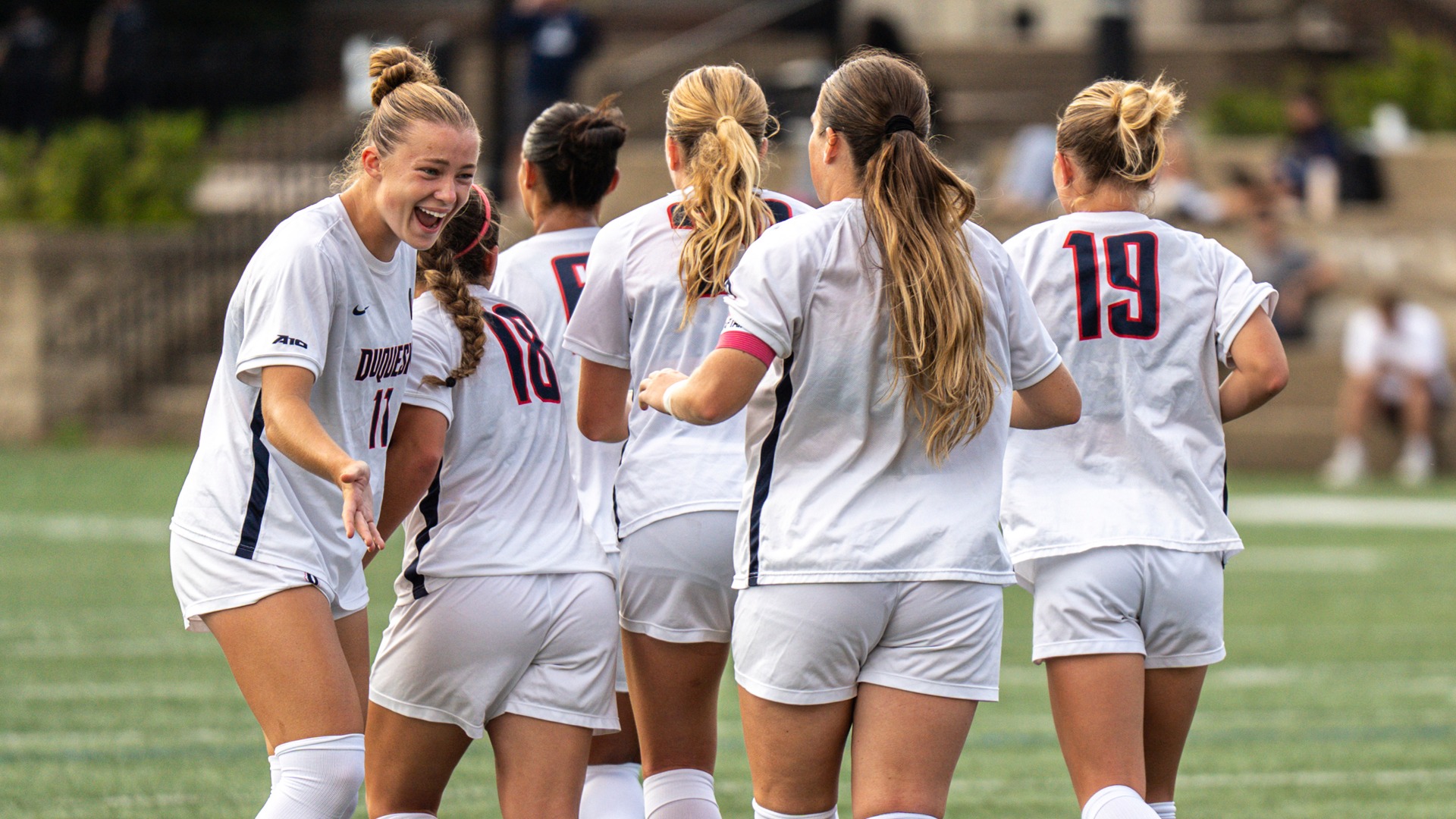 Reagan Basehore celebrates with teammates at Rooney Field vs. URI