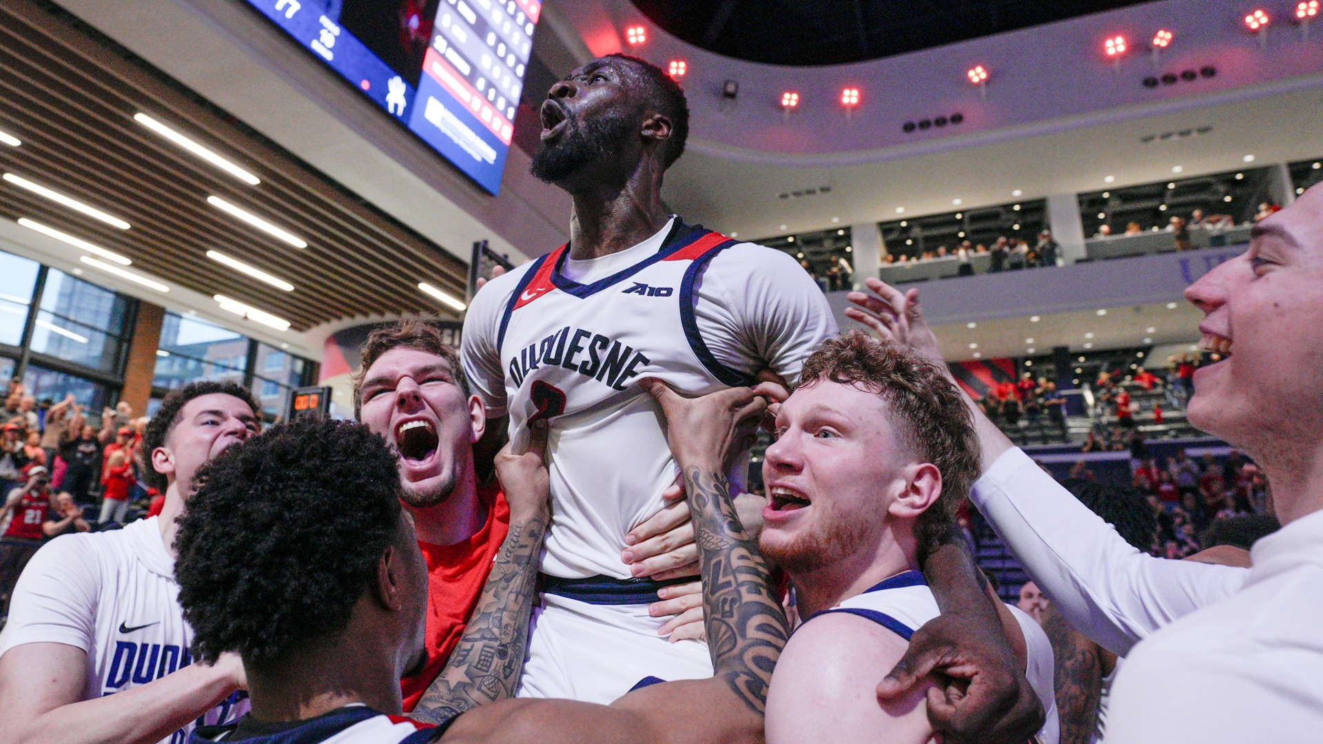David Dixon celebrates with teammates after the Dukes defeat Richmond at UPMC Cooper Fieldhouse.