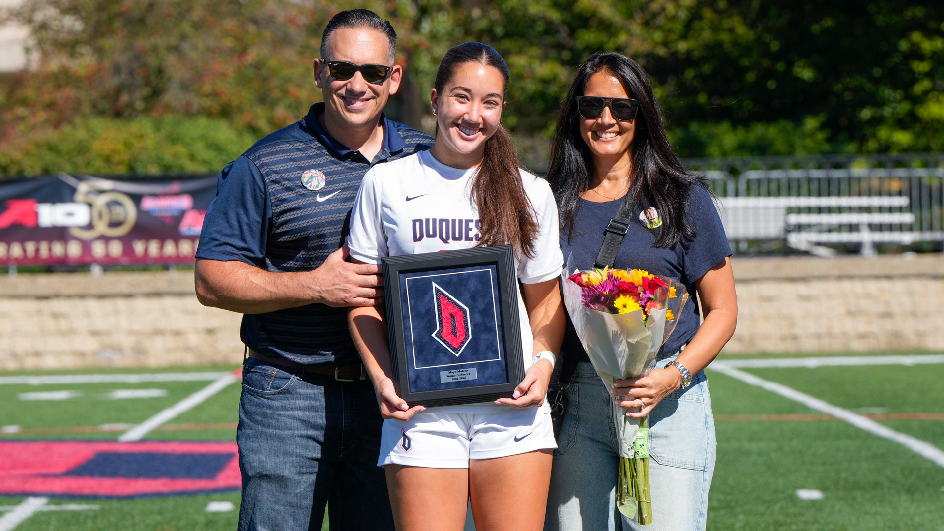 Maya Matesa poses with her parents on Senior Day at Rooney Field prior to Duquesne's game vs. George Mason.