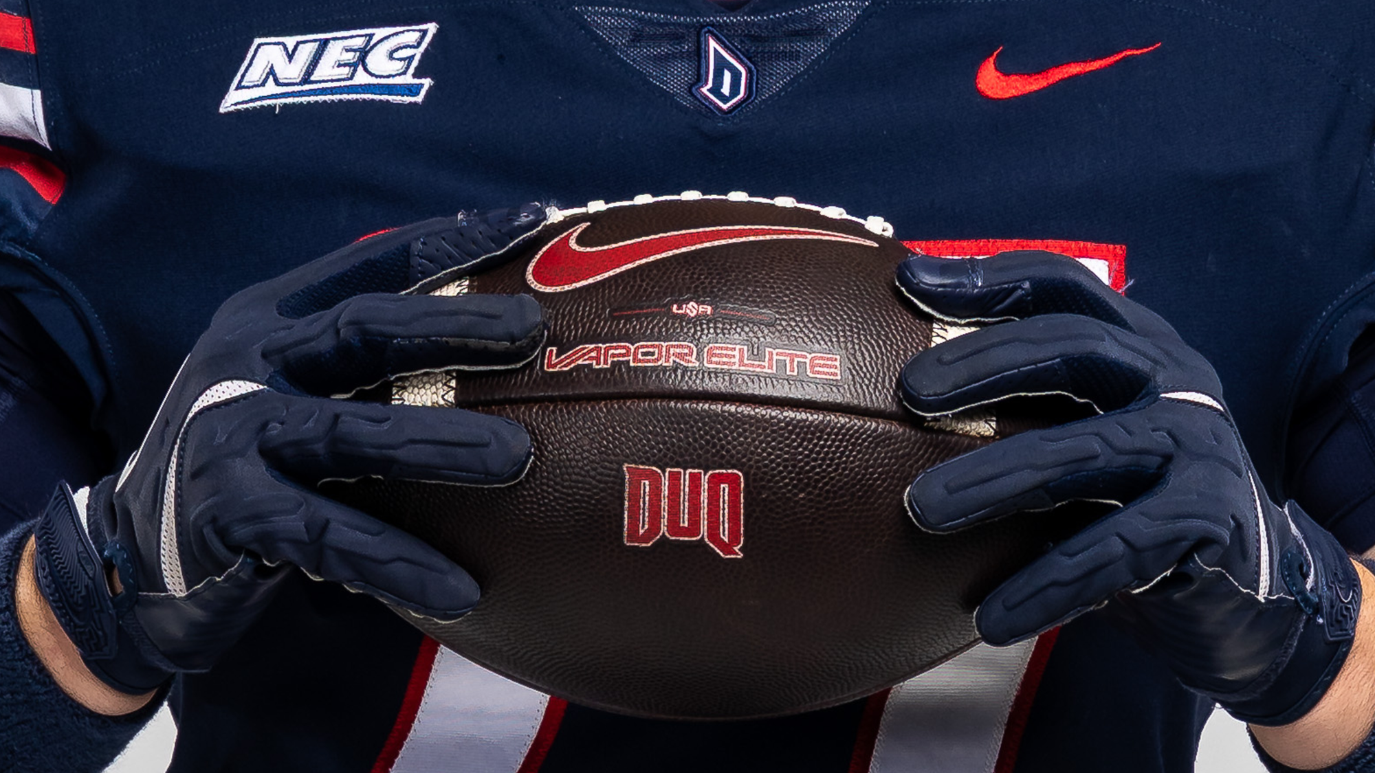 DUQ Football in front of jersey