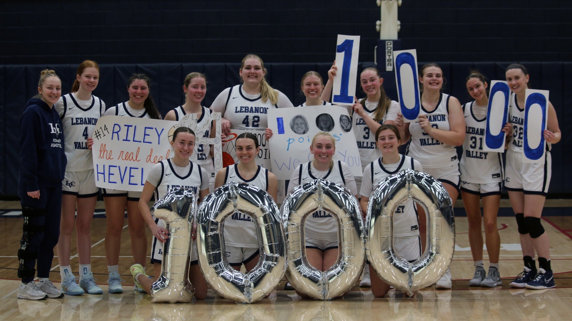 Riley Hevelow with teammates after scoring 1000th career point