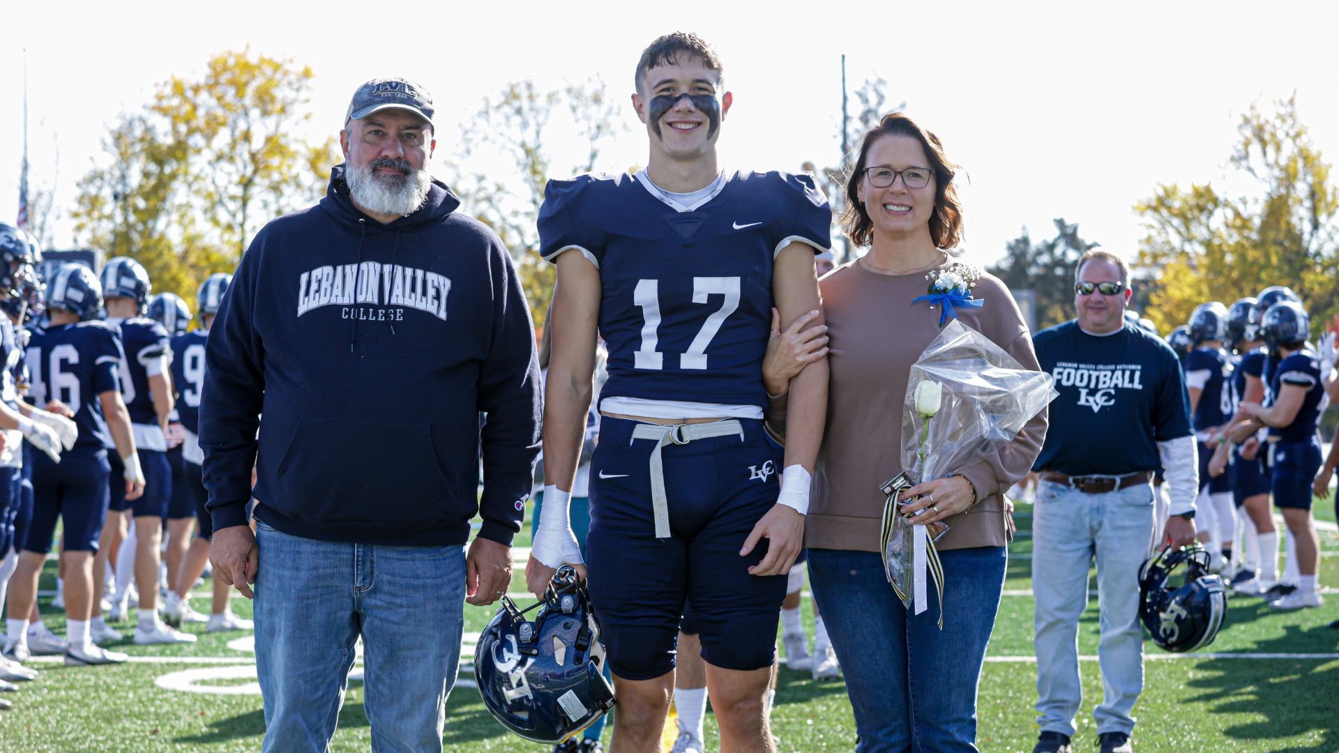 Carter Foust with parents on Senior Day