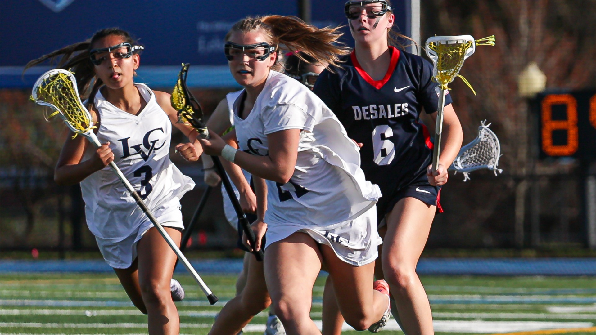 Chloe Moser running with ball in stick after winning draw