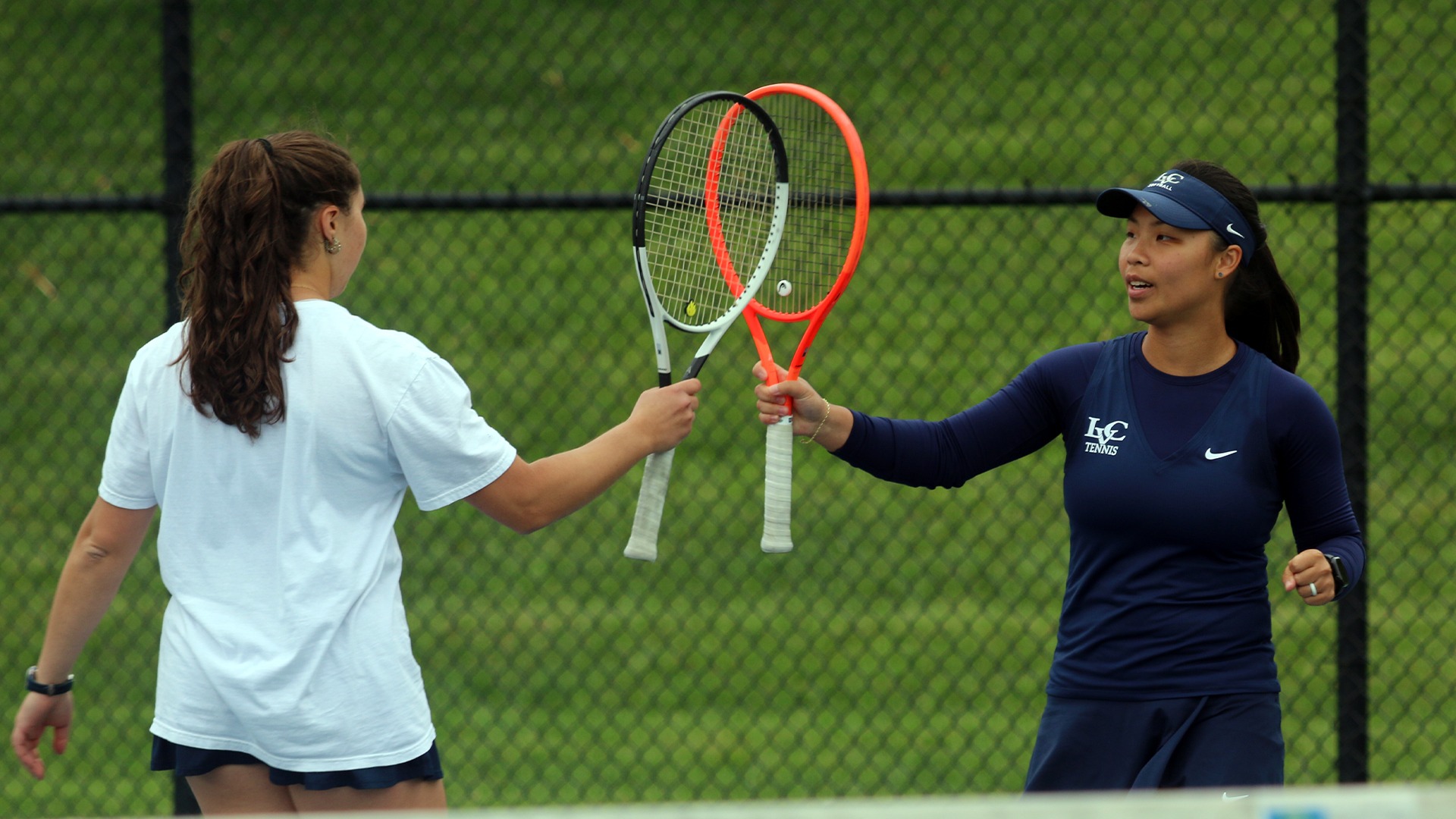 Erika Badner and Catherine Stone touching racquets