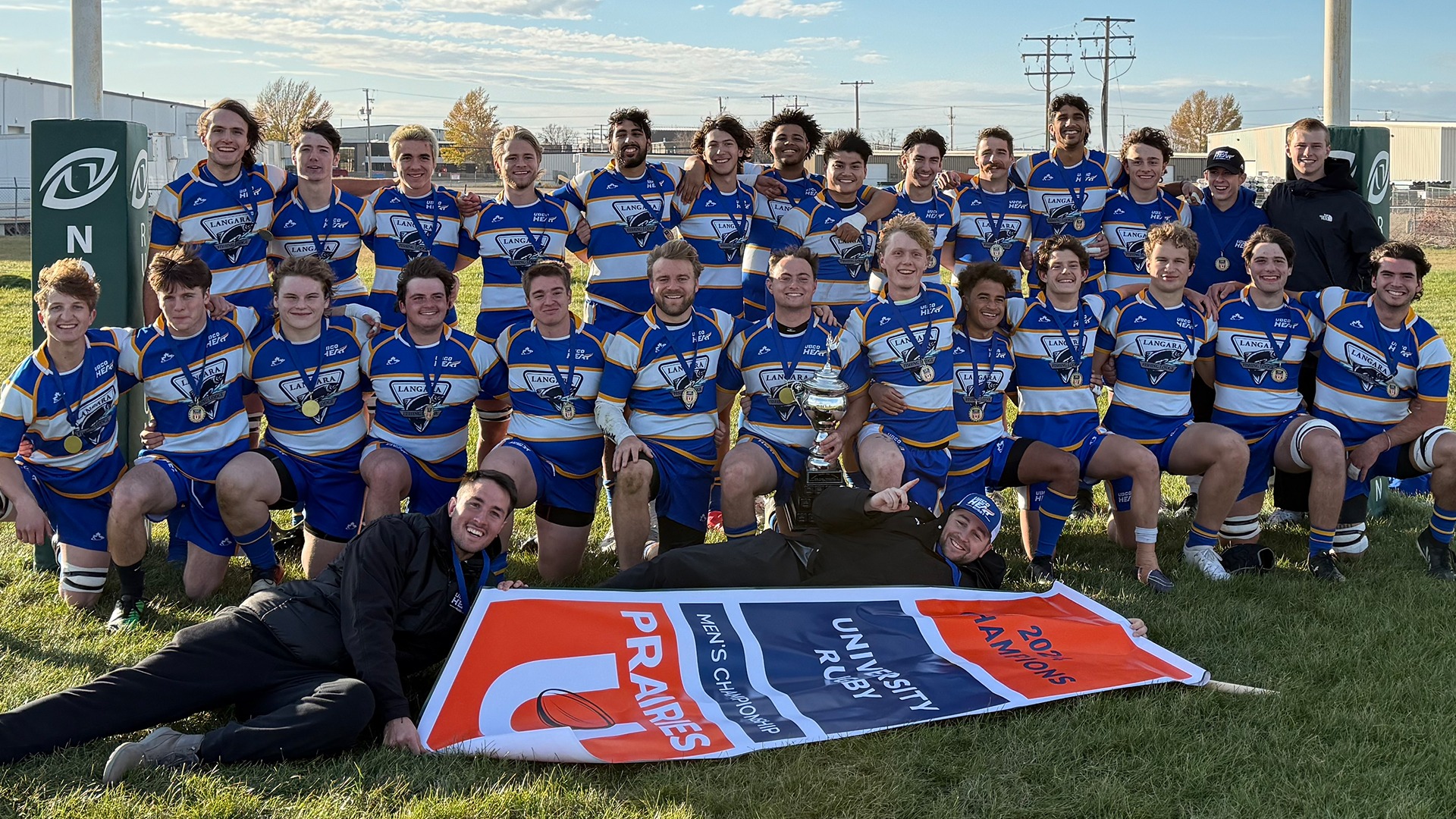 Members of the UBCO Heat men's rugby team pose with the championship banner and trophy following their 12-5 win over the University of Alberta in the gold medal match of the Prairie U Championship.