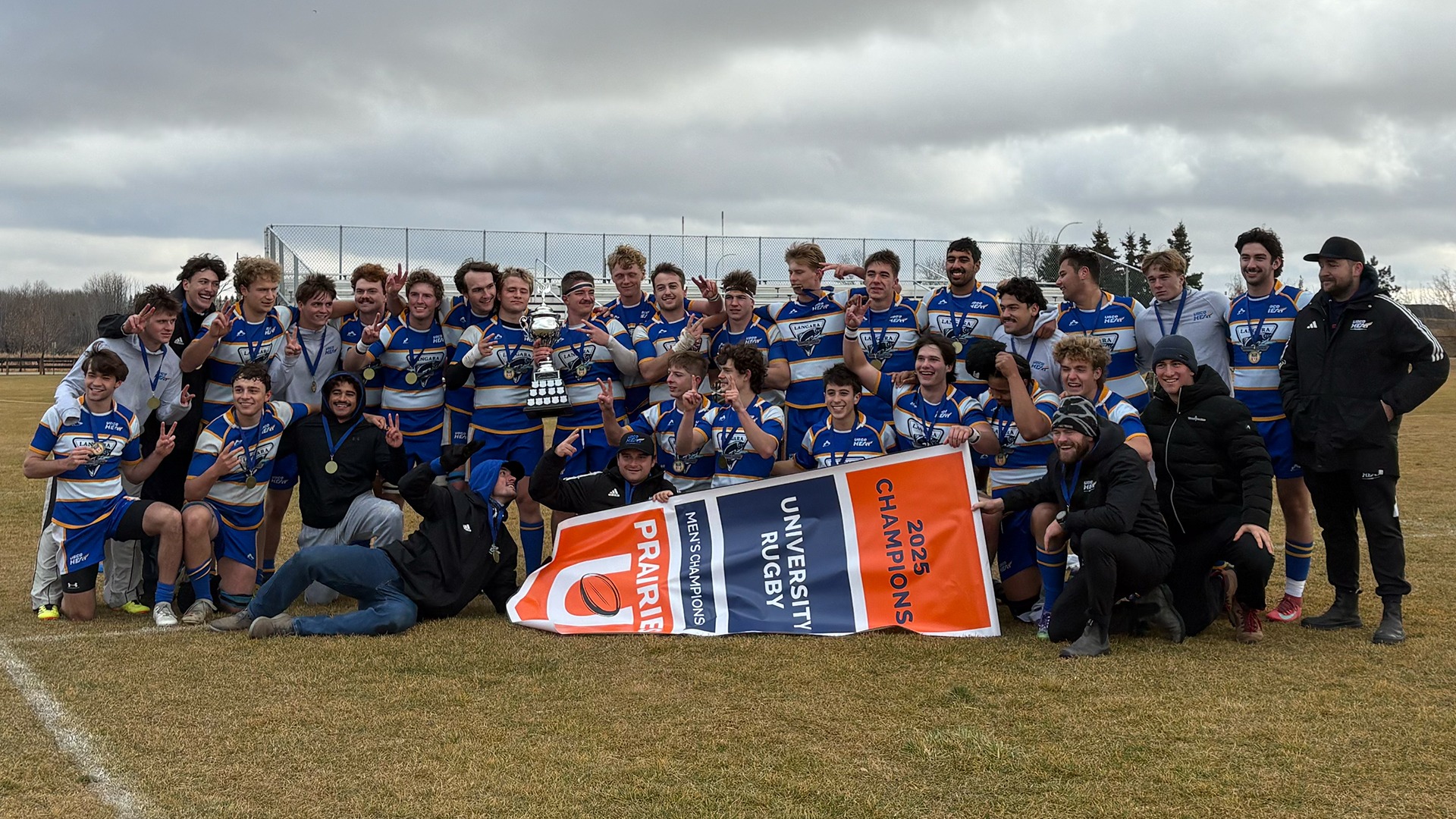 The UBCO Heat men's rugby team poses with the championship trophy and banner following their win over the University of Alberta in the 2025 Prairies U Championship final in Edmonton.