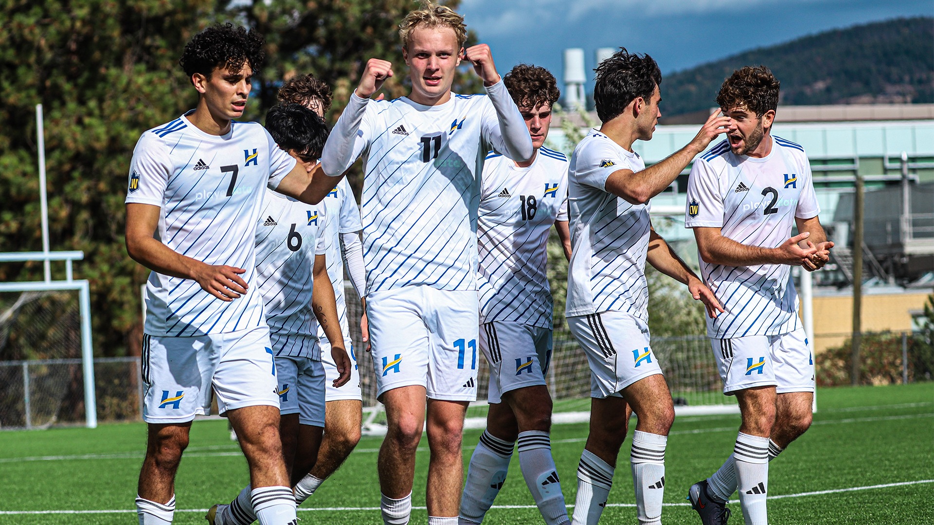 UBCO forward Jaise Shaw, surrounded by his teammates, celebrates scoring a goal against the UNBC Timberwolves at Nonis Sports Field.