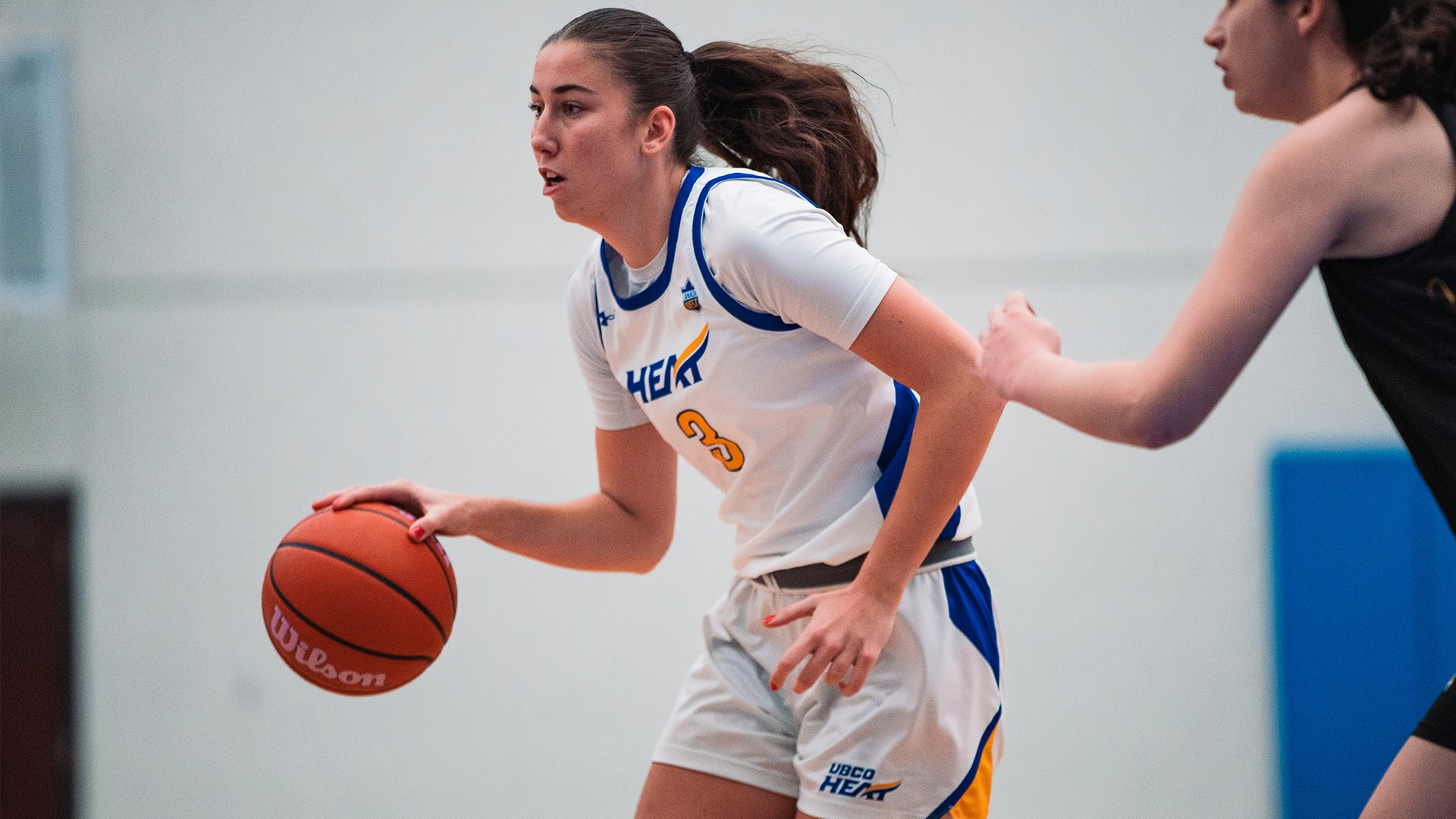 UBCO forward Tennyson McCarthy dribbles past her defender during action against the UNBC Timberwolves at the UBCO Gymnasium