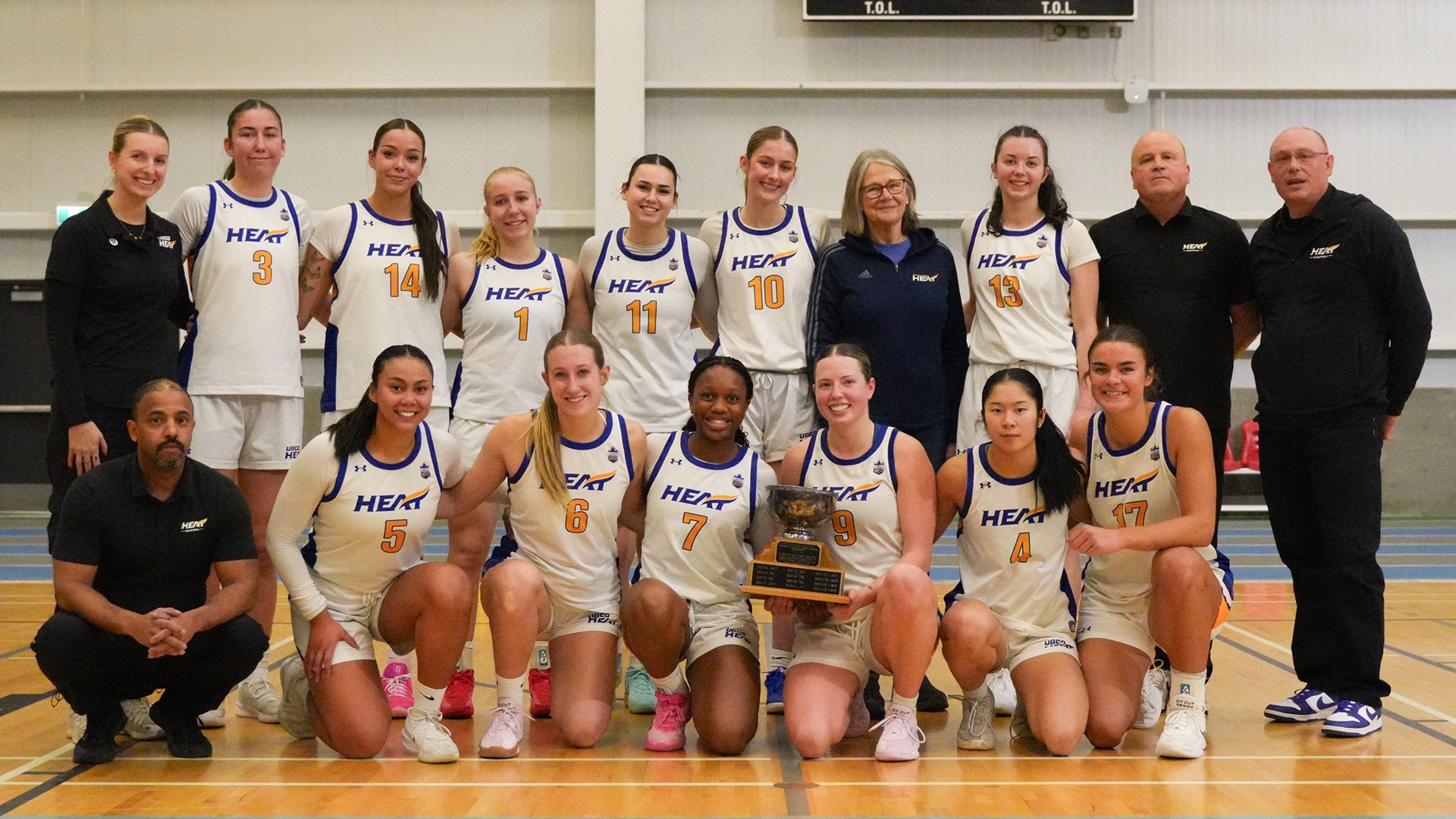 The UBCO Heat women's basketball team poses with the Presidents' Cup trophy following their game against the Thompson Rivers WolfPack in Kamloops
