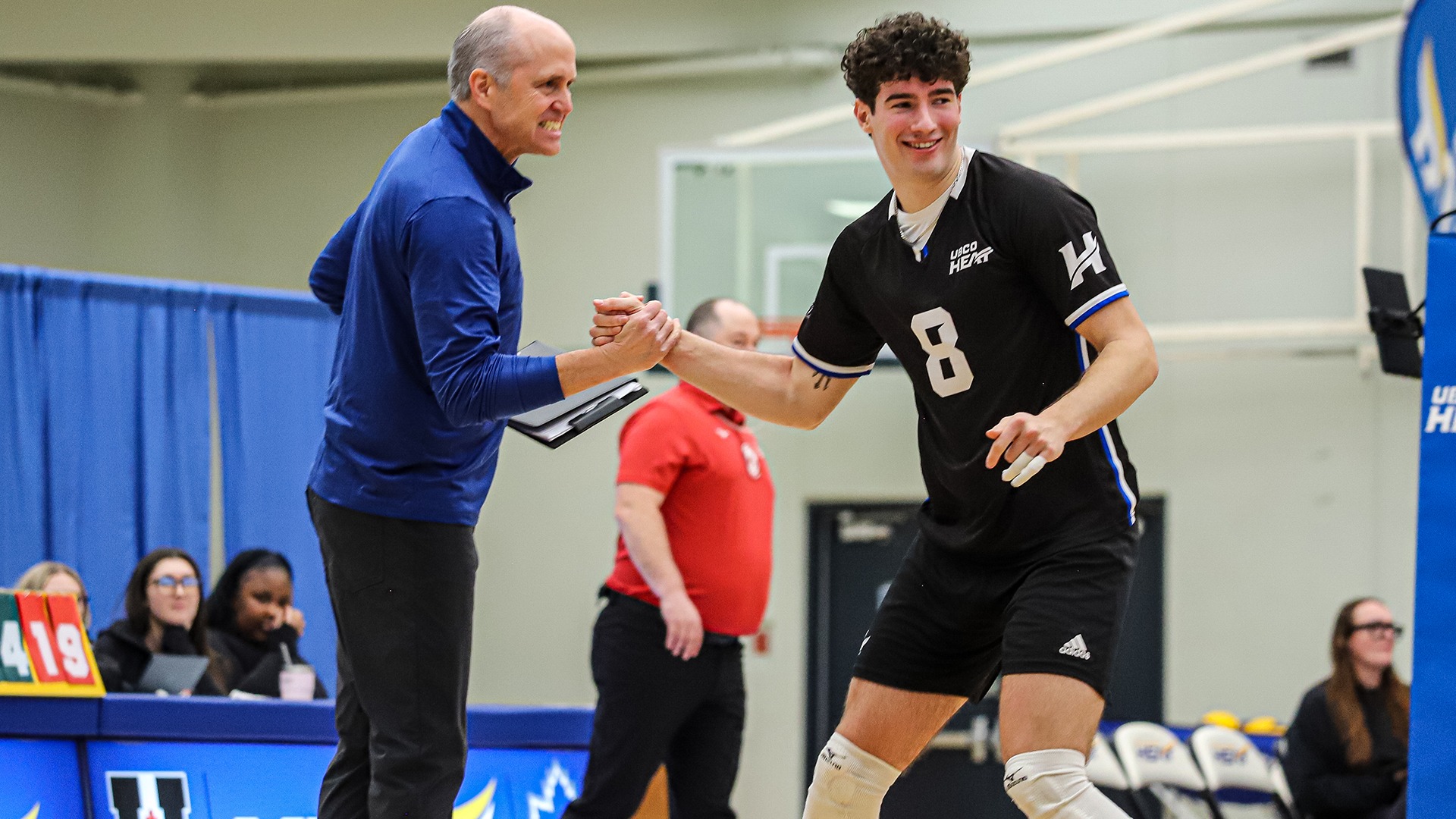 UBCO head coach Scott Koskie and outside hitter Seba Manuel celebrate a point during action against the Calgary Dinos at the UBCO Gymnasium.