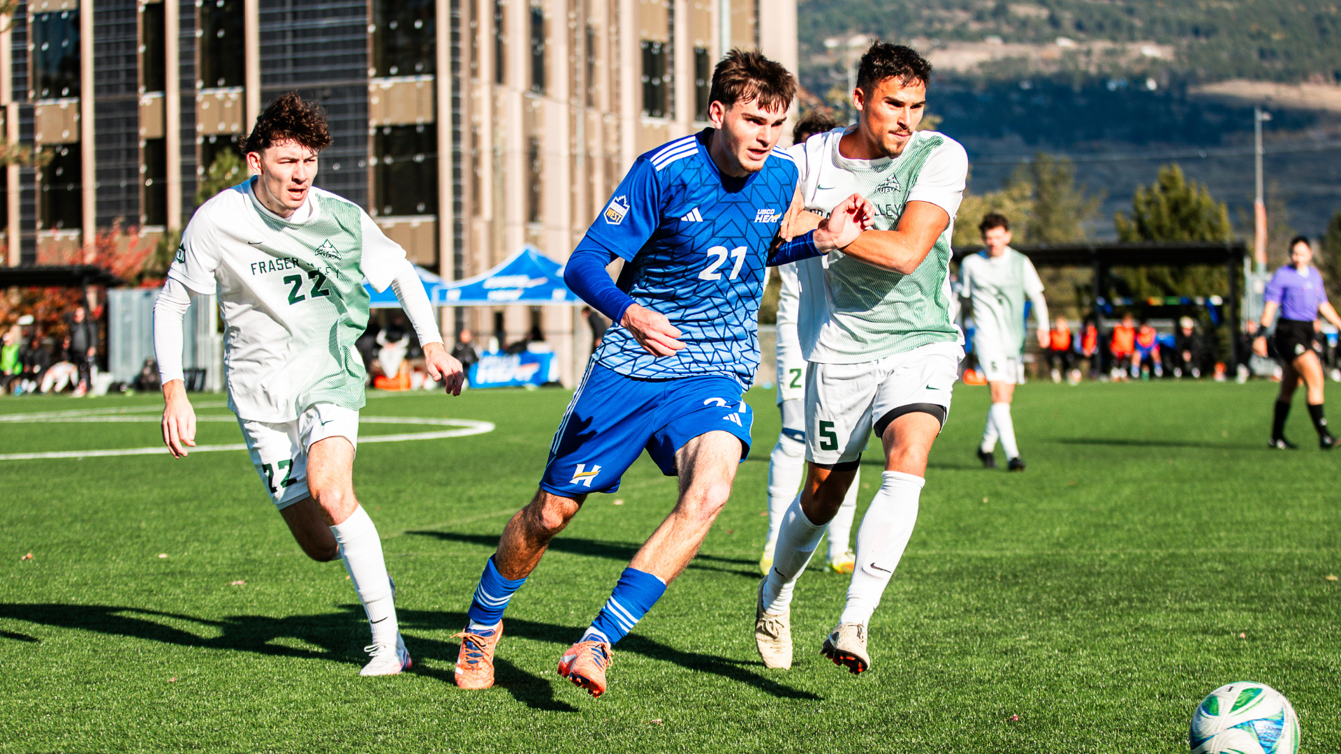 Mosi Klusman of the UBCO Heat mens soccer team dribbles the ball vs 2 UFV Cascades defenders