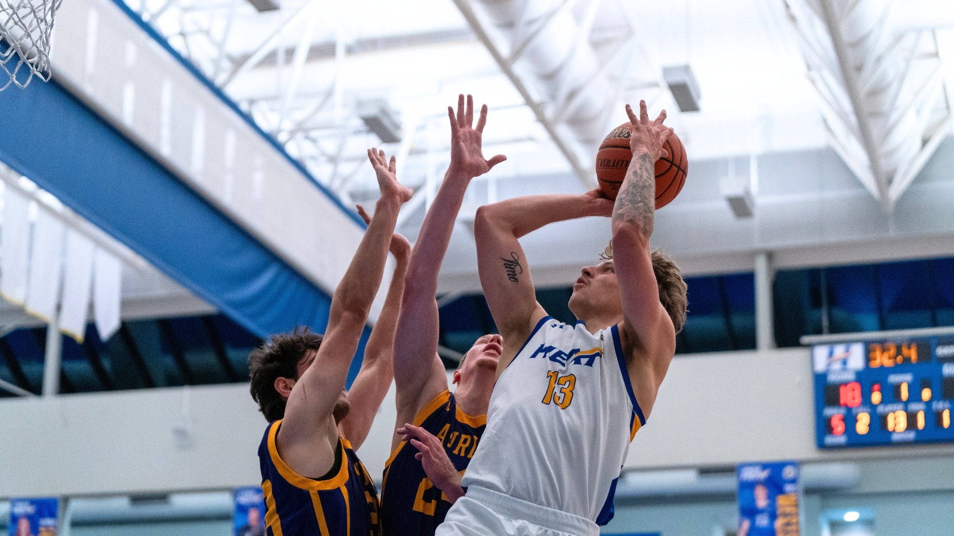 Wil Zylyk looks to shoot above two Laurier defenders