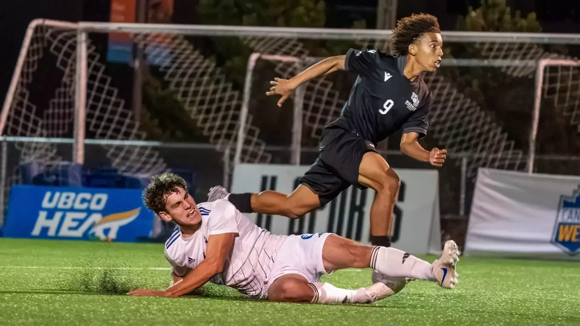 Charlie Prefontaine of the UBCO men’s soccer slide tackles the Saskatchewan Huskies