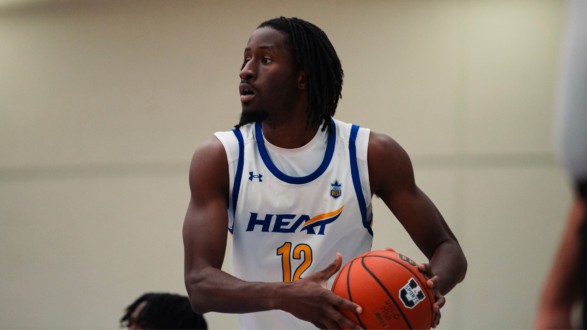 Lamine Conde of the UBCO mens basketball team holding ball looking to pass, stock