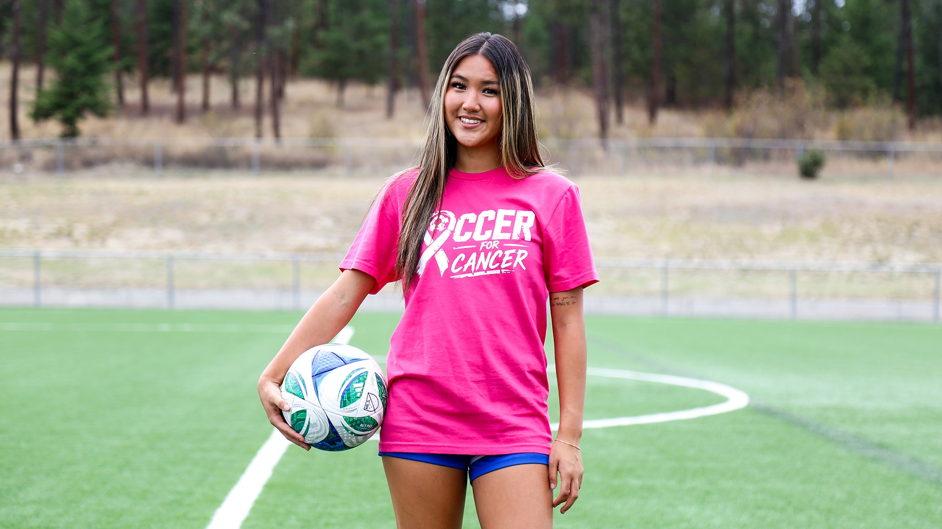 Aileen Ryou poses with her Soccer for Cancer tee shirt at Nonis Field