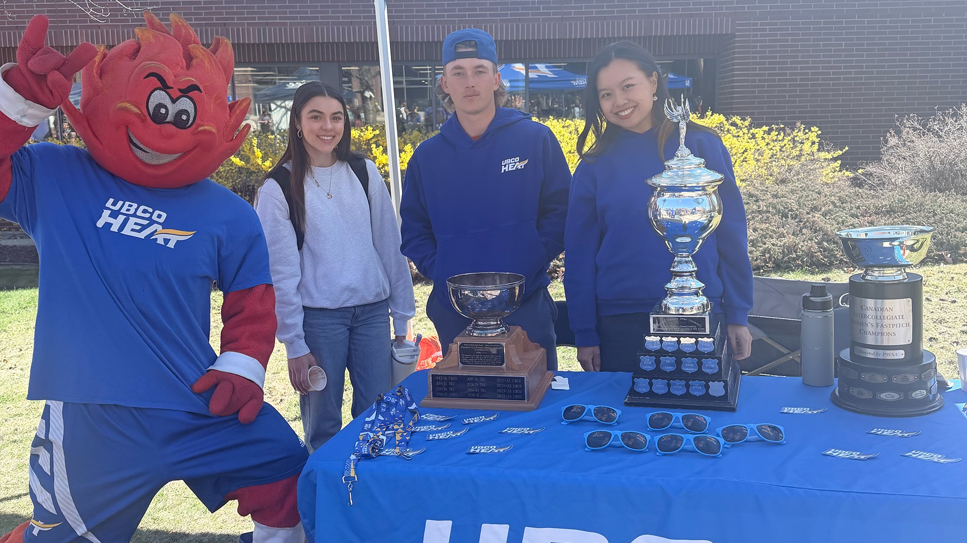 Members of the Heat golf team pose with UBCO Heat mascot Scorch at the Athletics tent during the 2026 Giving Day event in the UBCO Courtyard.