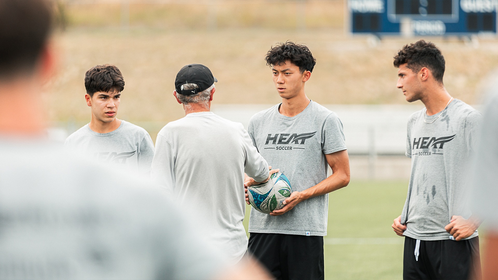 Heat men's soccer head coach Dante Zanatta chats with Andrew Matsugu during a break in training.