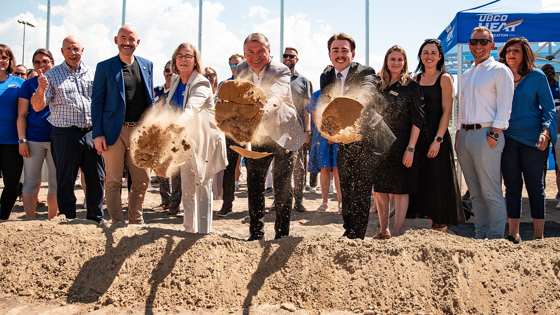 From left to right, Dr. Lesley Cormack, Kelowna Mayor Tom Dyas and Students' Union VP Naden Qually toss dirt from ceremonial shovels while flanked by members of Kelowna City Council and UBCO staff.