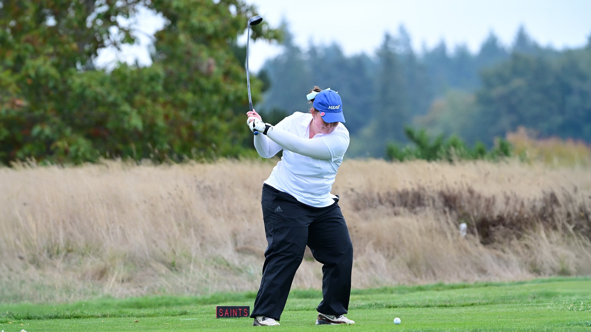 Julia Alexander-Carew, a UBCO women's golfer, about to hit a golf ball at the Grisham Memorial Shootout.