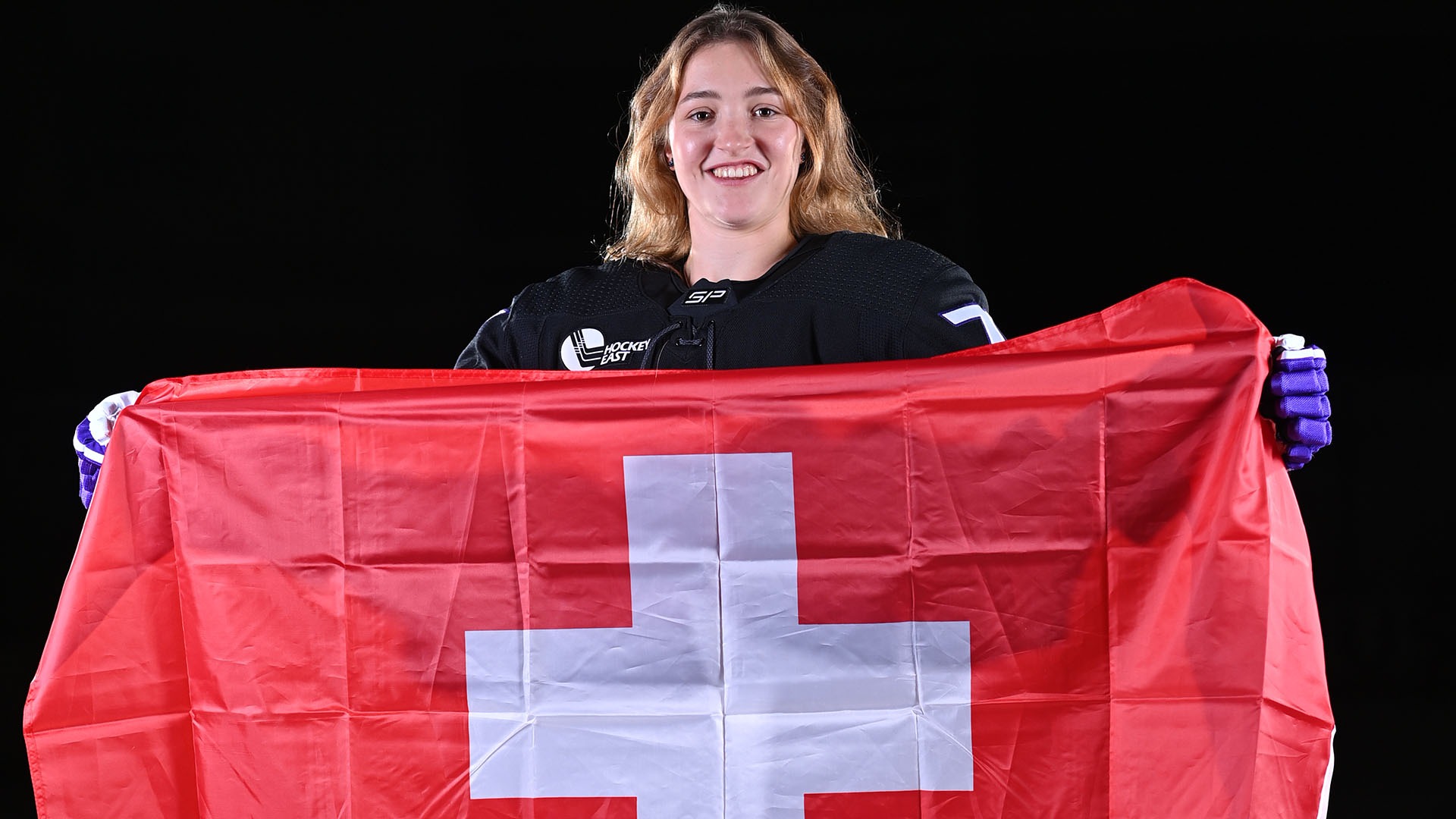 Naemi Herzig holding the Swiss flag