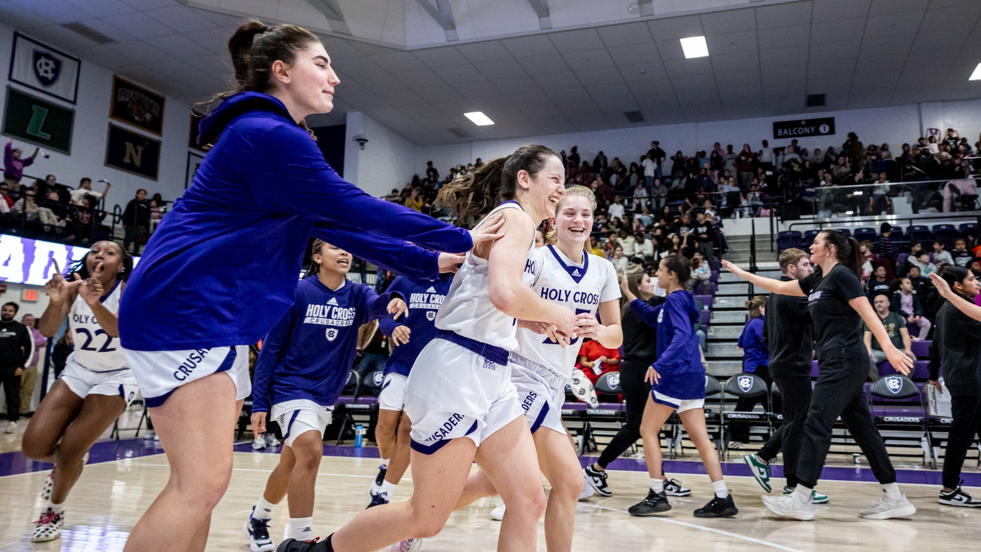 Members of the women's basketball team celebrate with senior Kaitlyn Flanagan (#5) after she hit the go-ahead layup in the 46-45 win over Vermont on Dec. 16. 