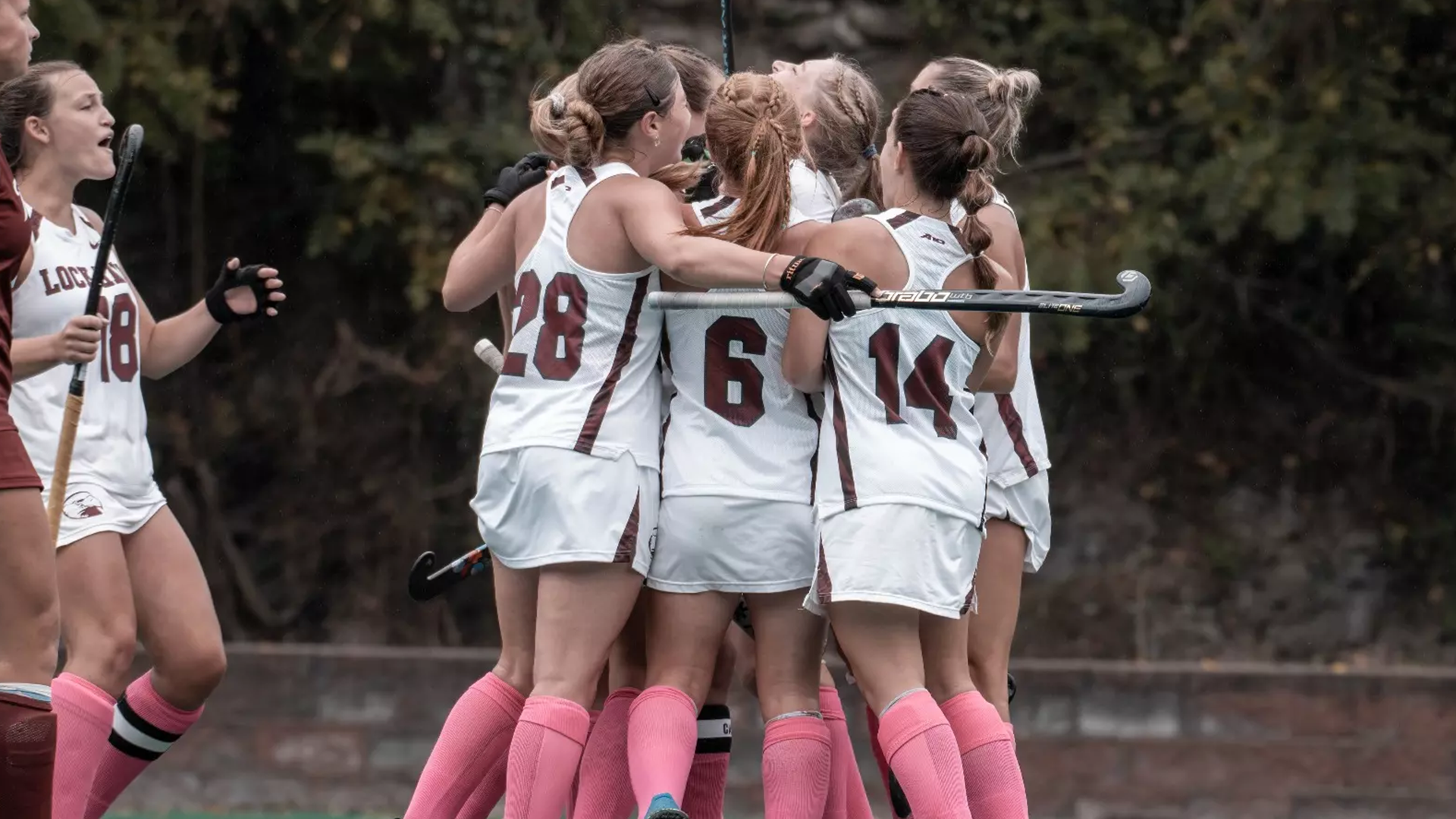 Field Hockey huddles in celebration following a goal