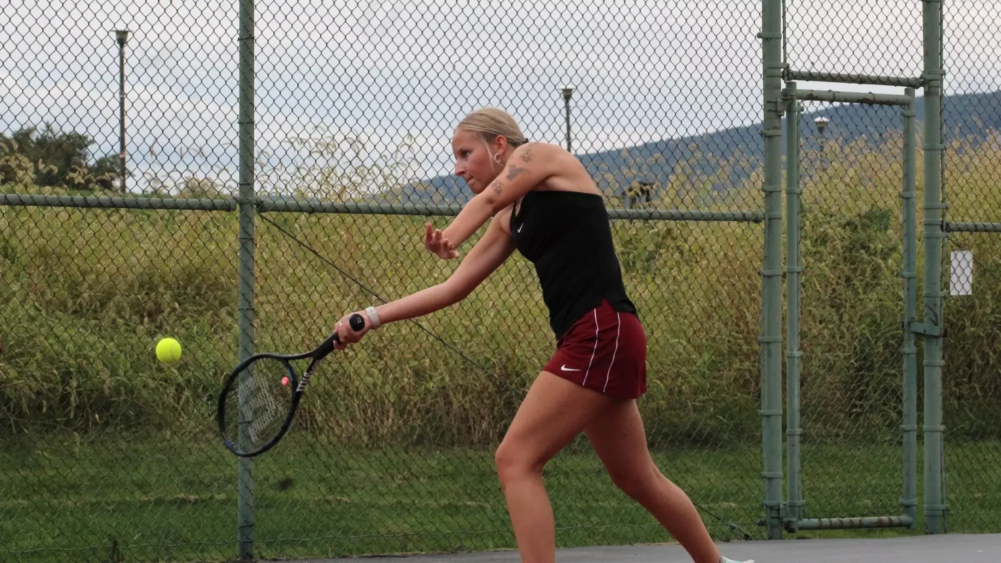 Emma Ackley returns during a women's tennis match