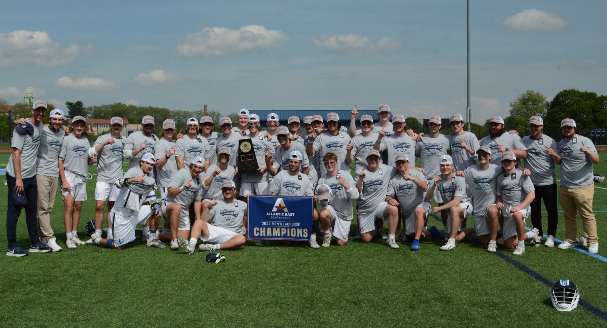 2025 Men's Lax DG Championship photo with shirts, hat, and banner