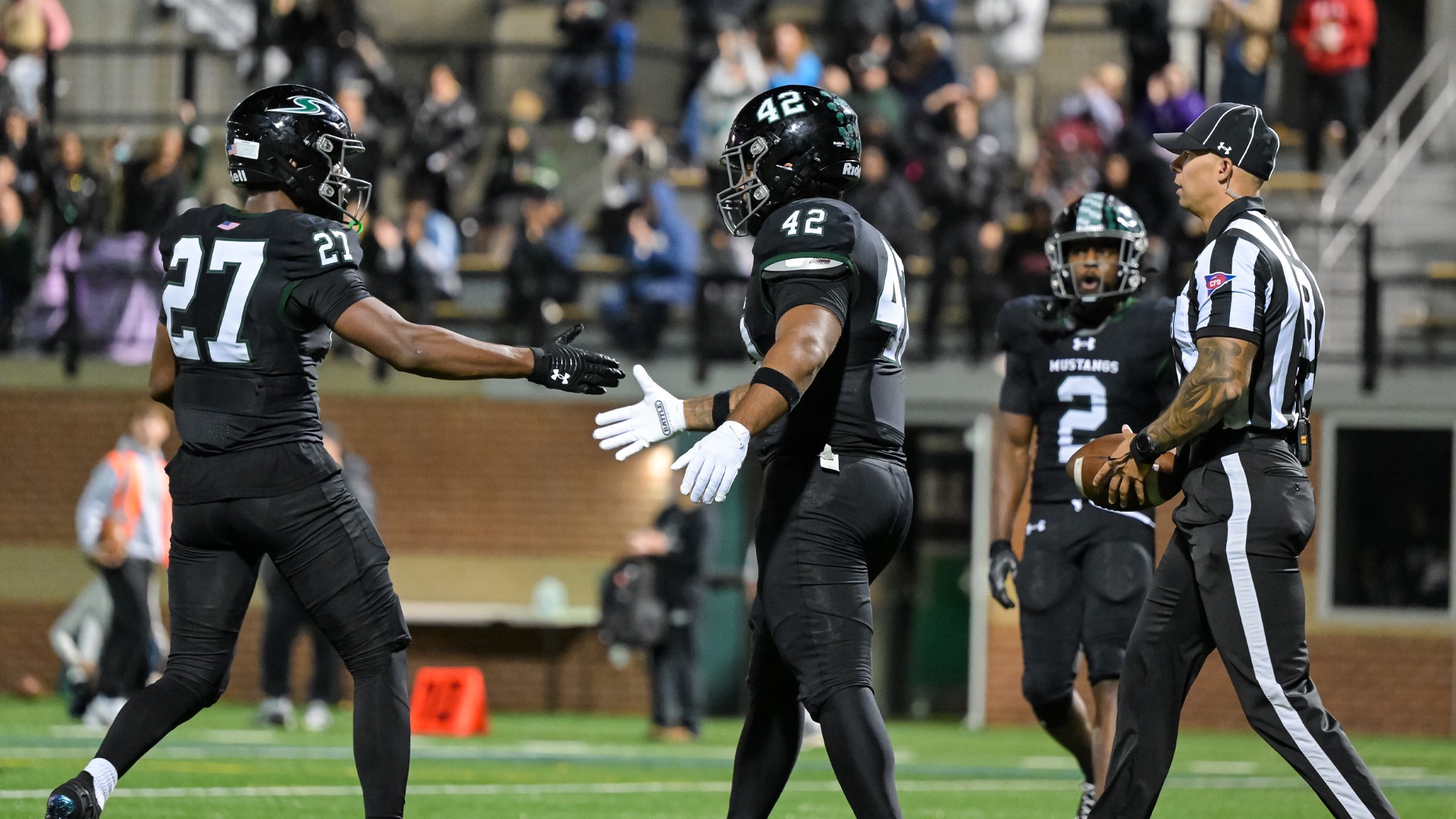 Two players celebrating a touchdown in the end zone