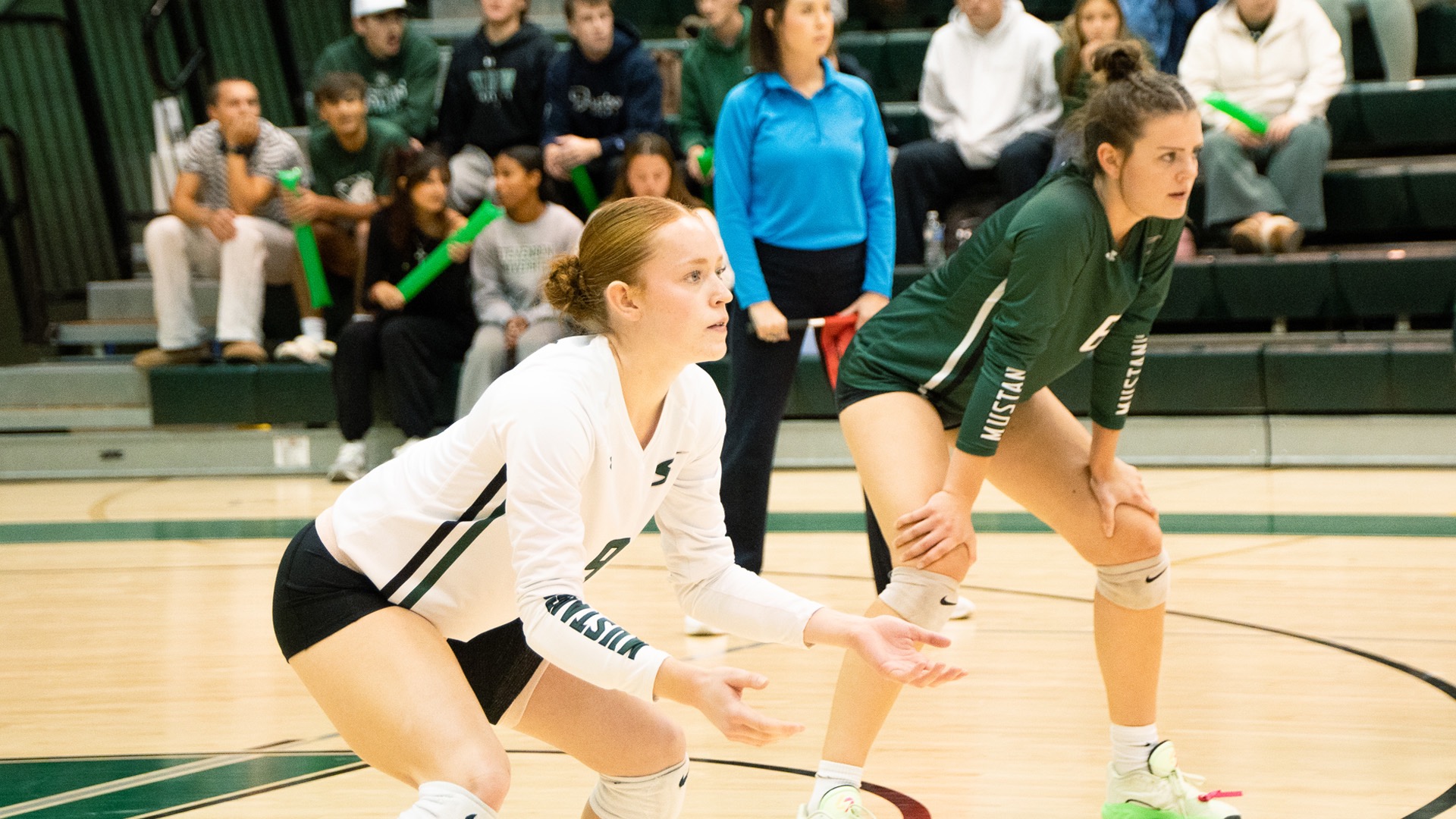 Two Women's Volleyball Players ready to receive the opposing serve